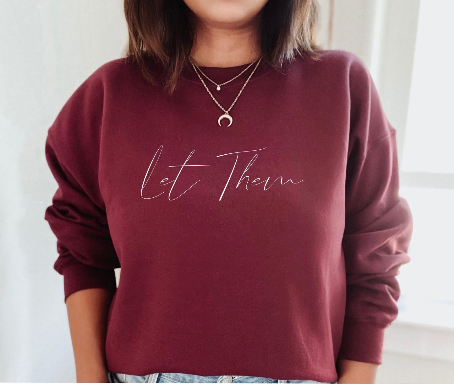 Let Them sweatshirt close-up showing soft fabric and graphic print detail in maroon