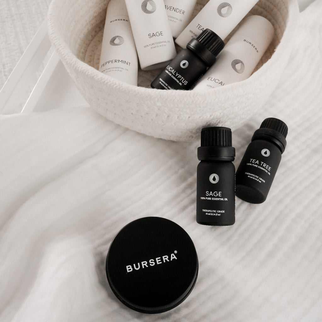 Bursera essential oil bottles and containers on a textured surface