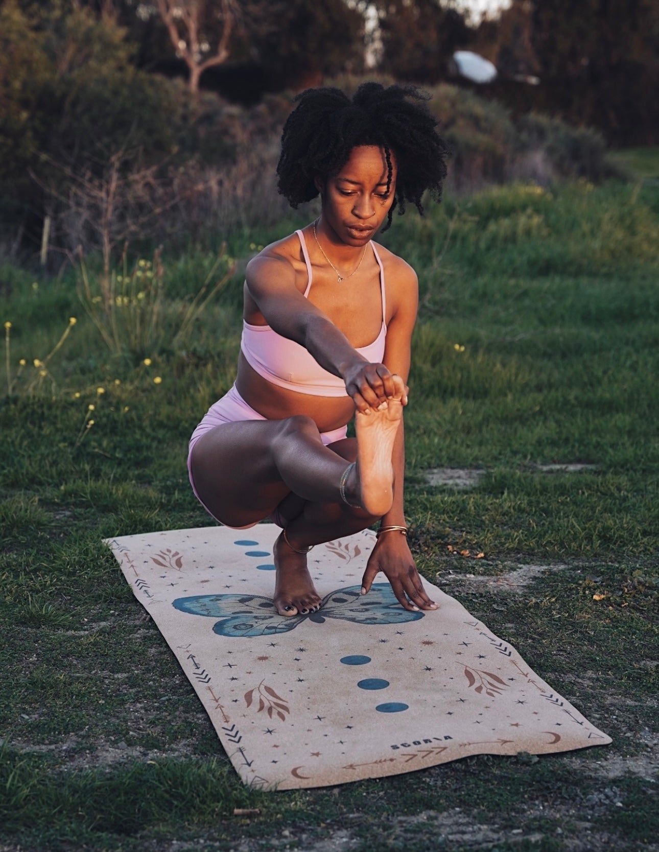 woman practicing yoga on a cork yoga mat with butterfly design