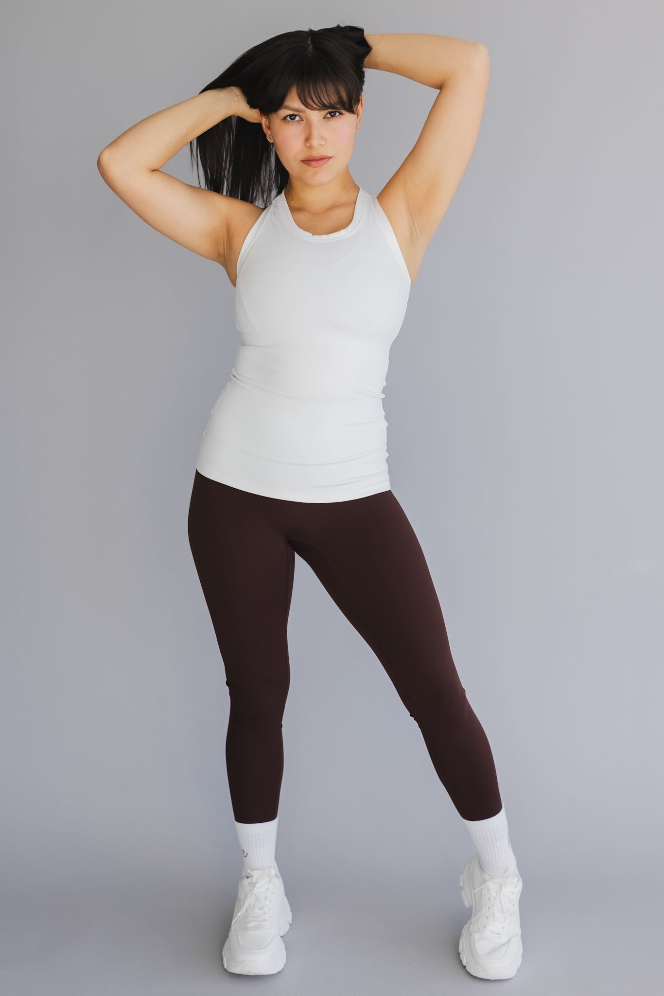 full body view of a woman wearing 25 inch barely there leggings in coffee for pilates and casual athleisure