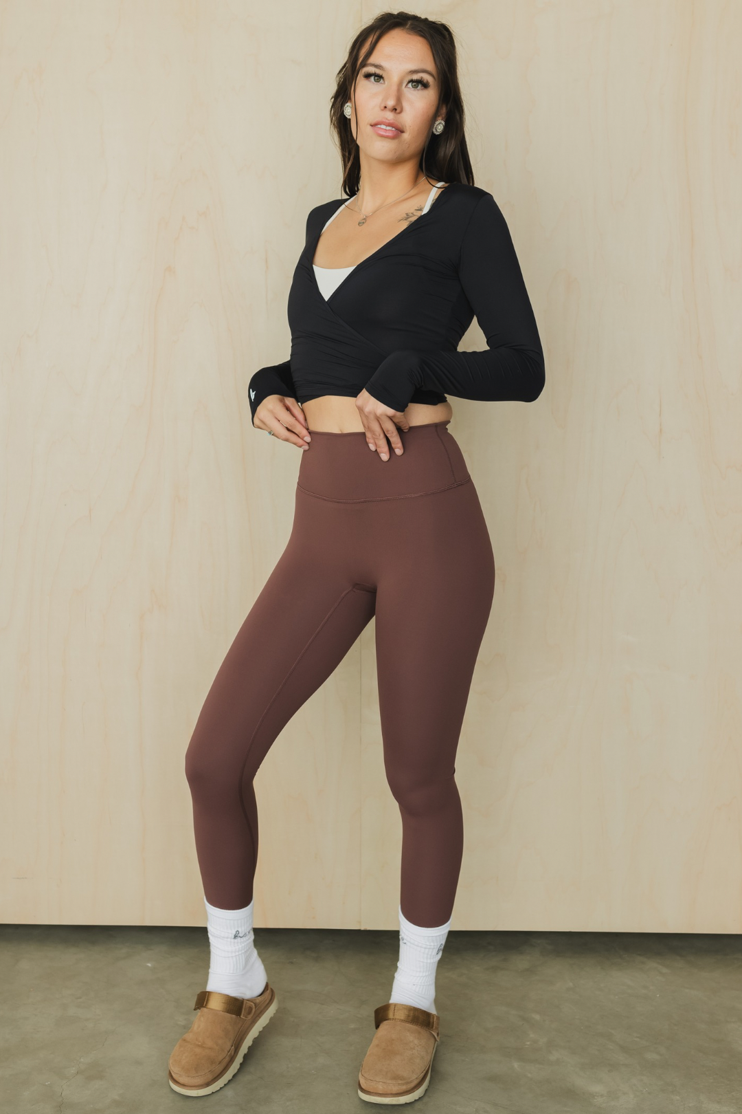 zoomed out front view of a woman wearing running pant in russet for running and casual athletic wear