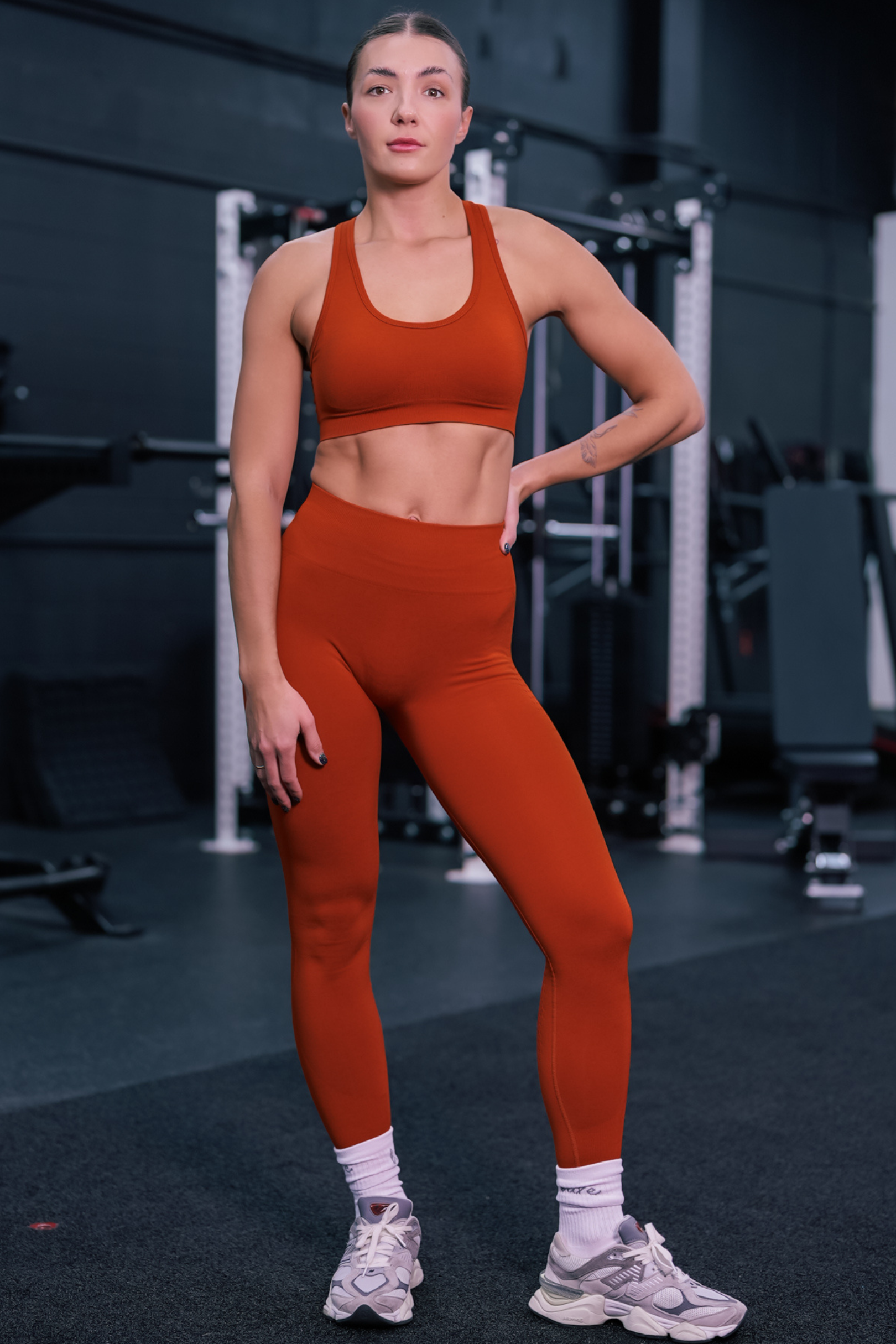 full body view of a woman wearing silhouette seamless sports bra in vermillion red with matching pants for yoga and fitness