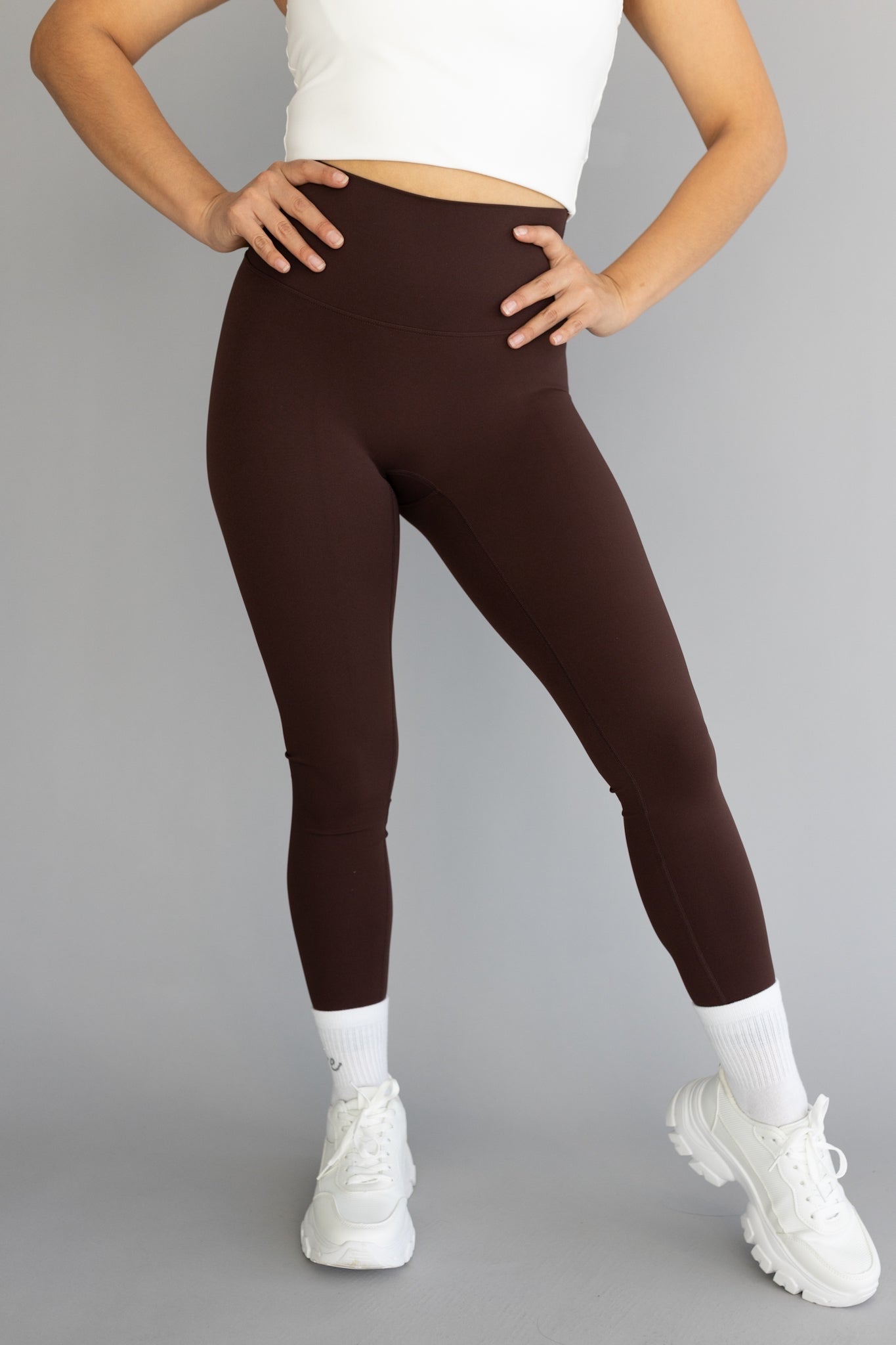 front view of a woman wearing 25 inch barely there leggings in coffee for pilates and casual athleisure