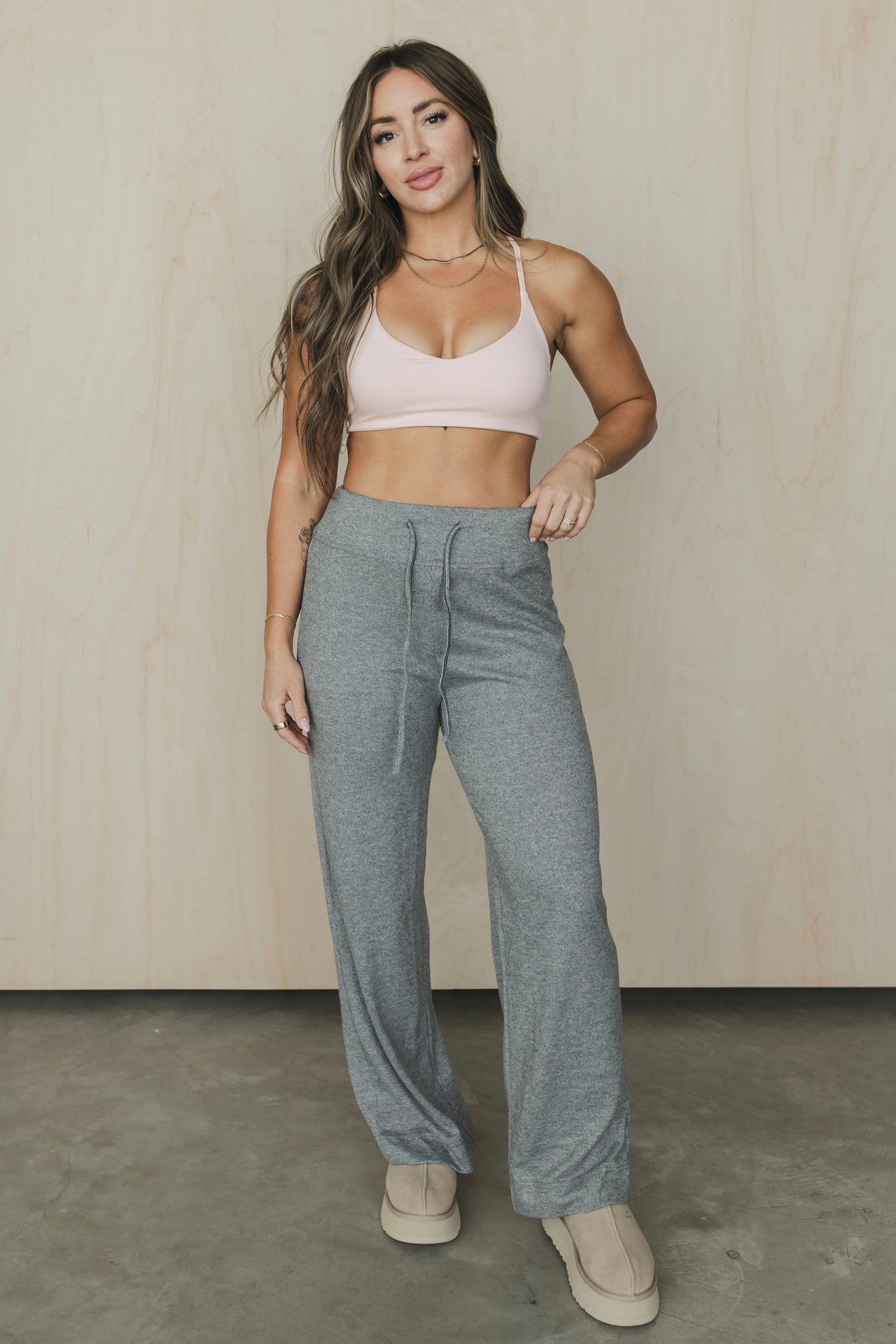 full body front view of woman wearing divine sports bra in light pink for yoga and studio workouts