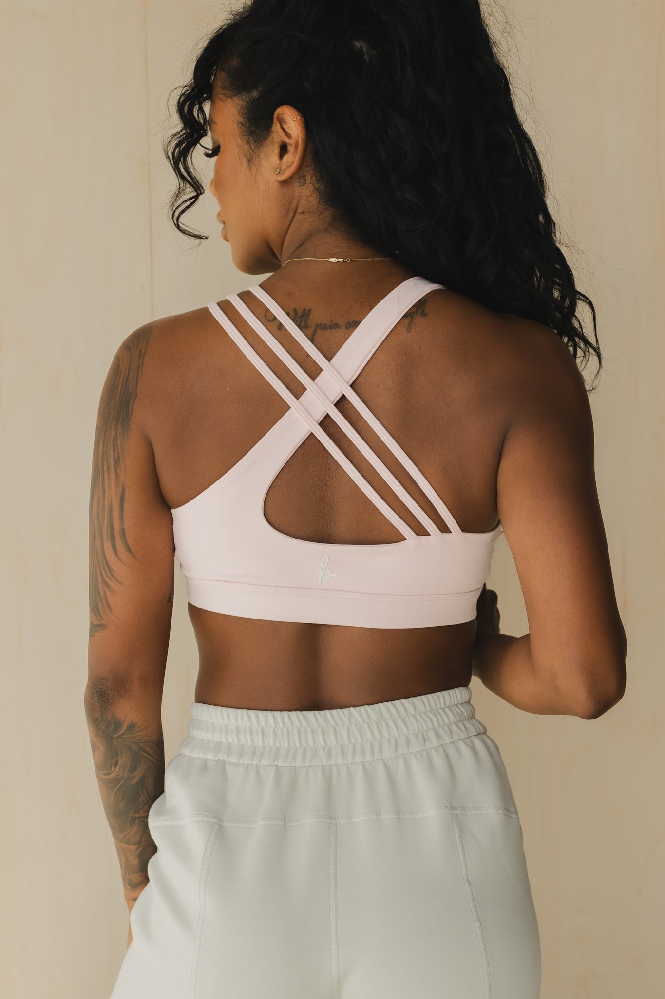 back view of a woman wearing S.F. V3 sports bra in pink lemonade for yoga and studio workouts