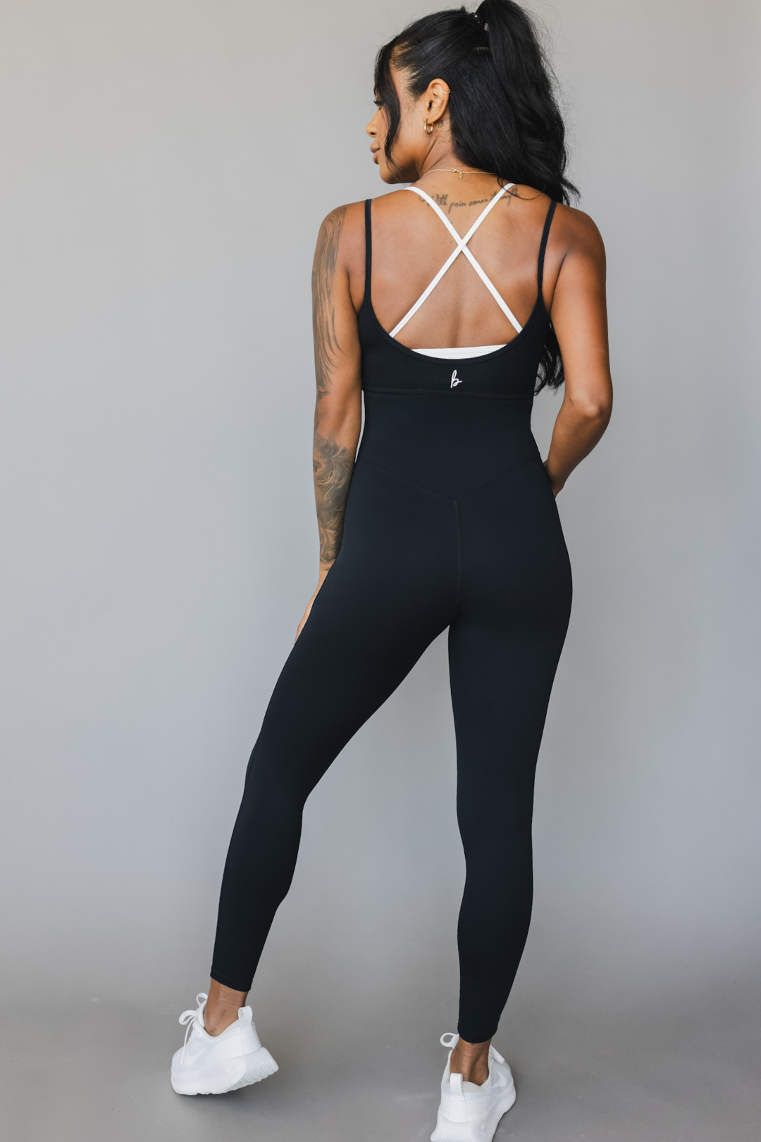 back view of a woman wearing tina bodysuit in black for yoga and studio wear