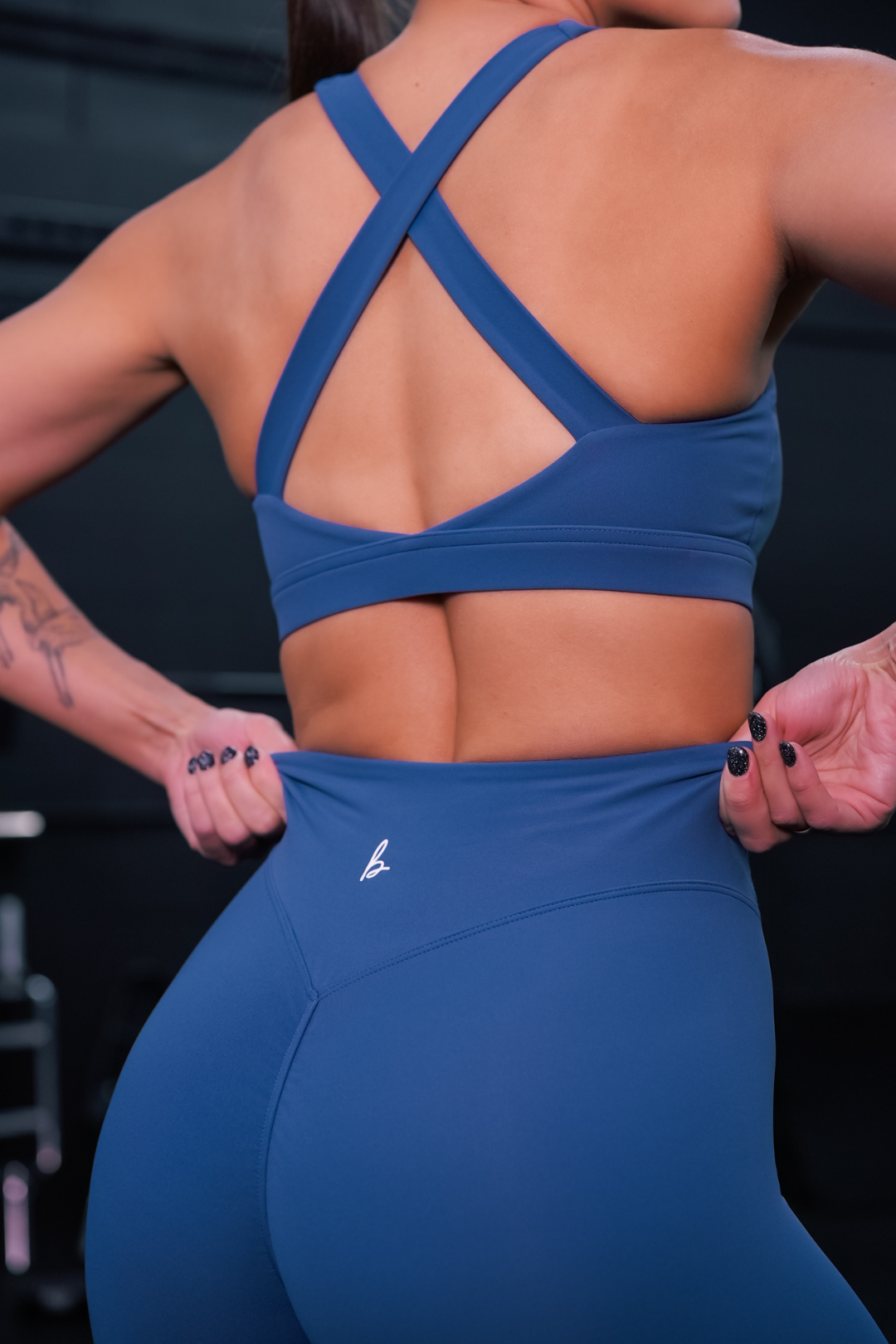 zoomed in back view of a woman wearing 27 inch fight or flight leggings in muted cobalt for pilates and everyday activewear