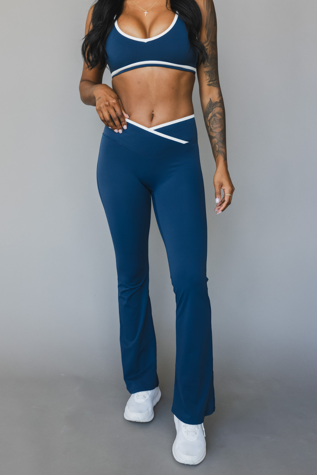 front view of a woman wearing flare leggings in winter blue with white trim for the gym and versatile everyday wear