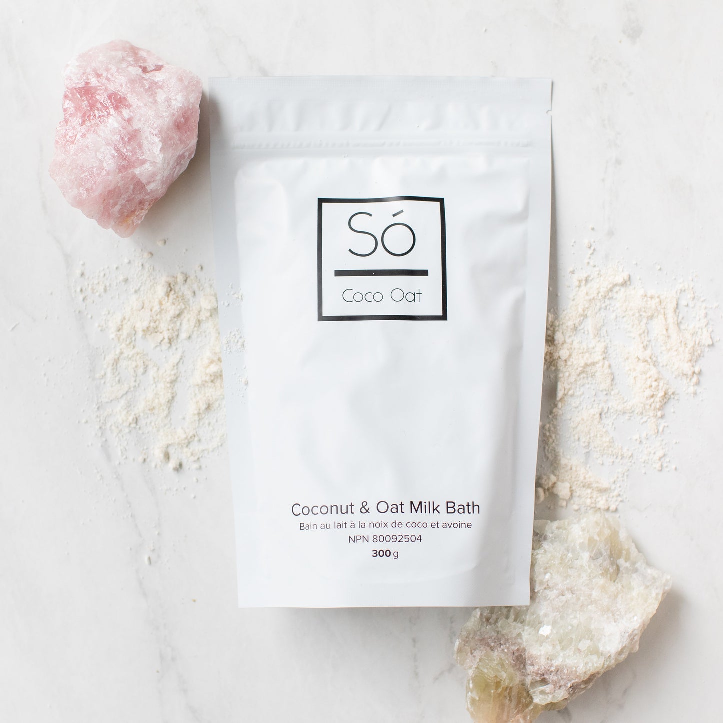 Coco Oat milk bath package with a pink rock and white powder on a light background
