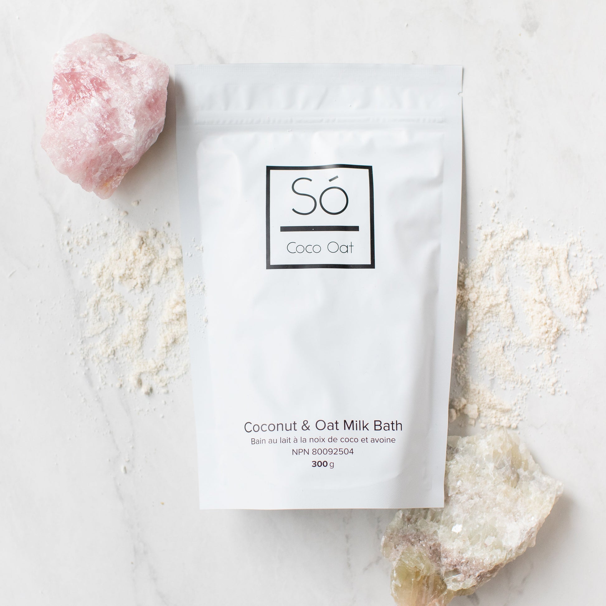 Coco Oat milk bath package with a pink rock and white powder on a light background
