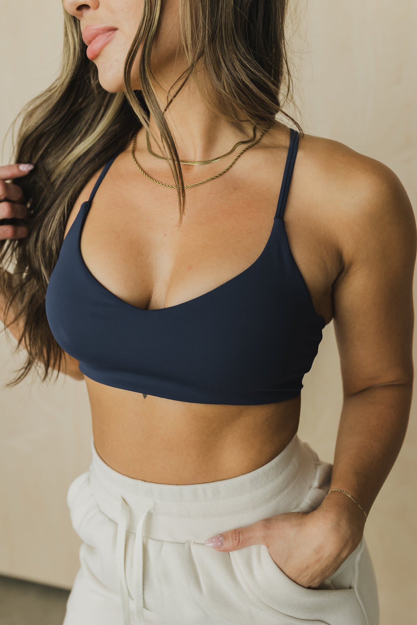 close up view of woman wearing divine sports bra in deep navy blue for the gym and activewear