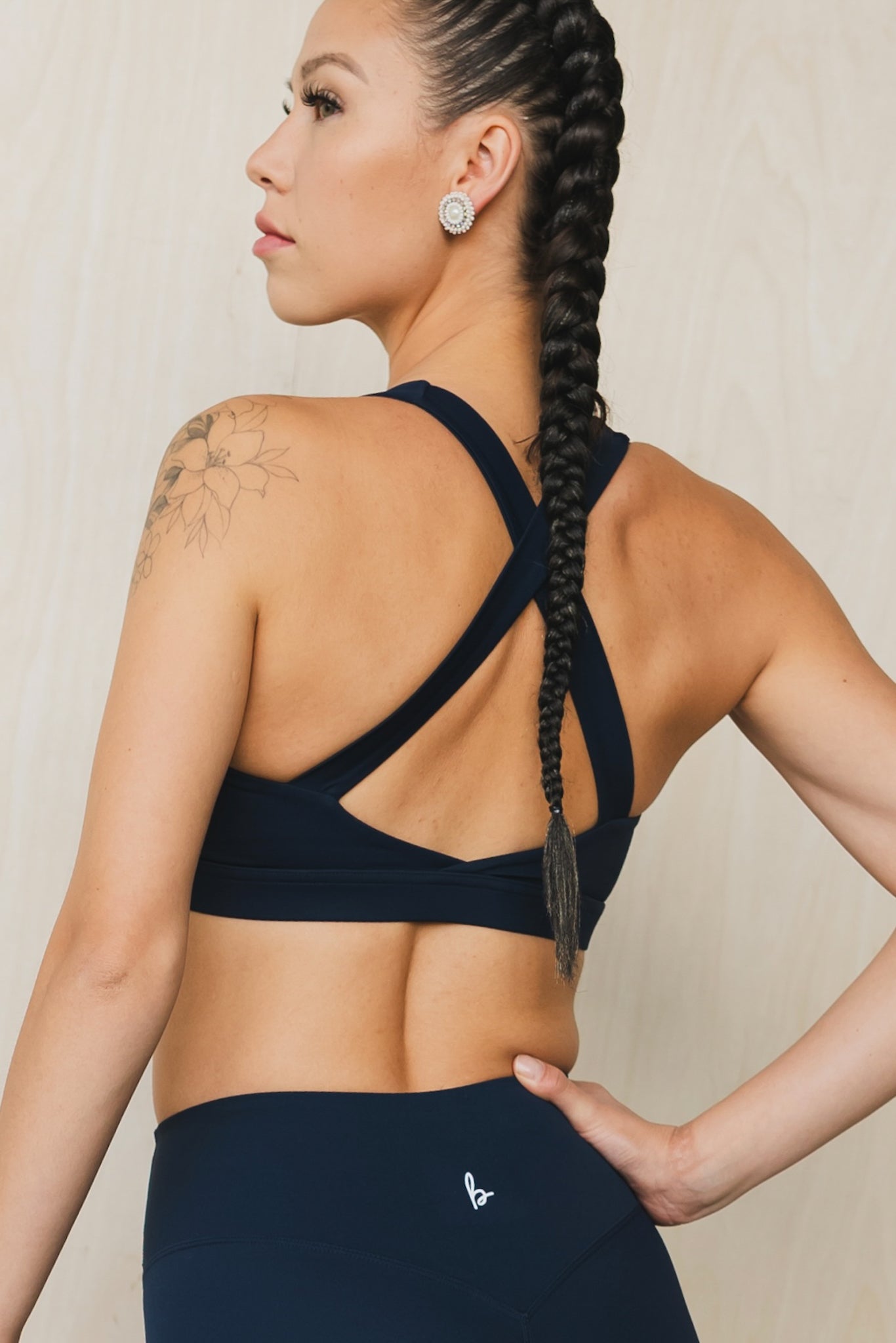 back view of a woman wearing a Fight or Flight high-support sports bra in midnight blue for yoga and fitness