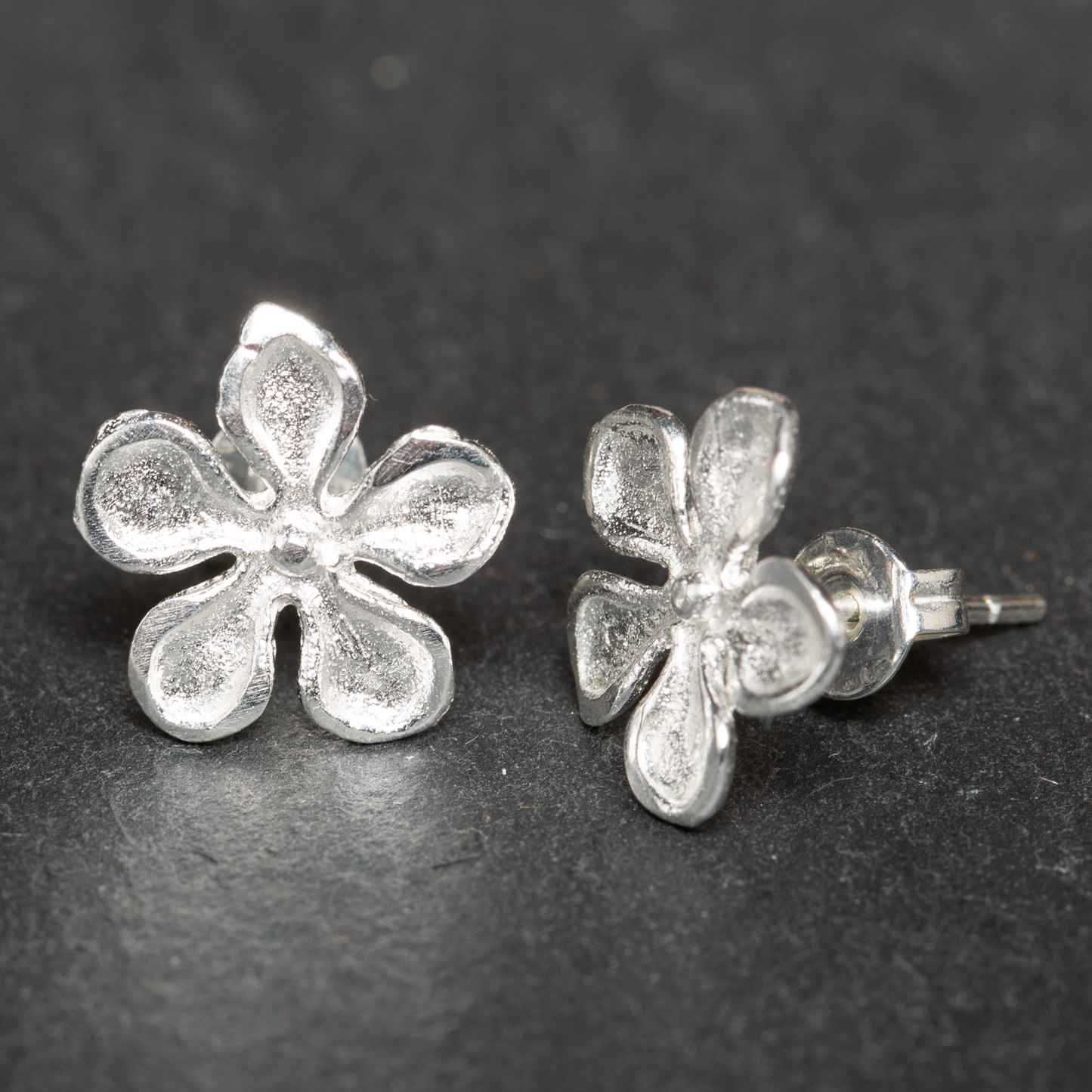 Silver plate hammered flower drop earrings artisan boho jewelry close up view