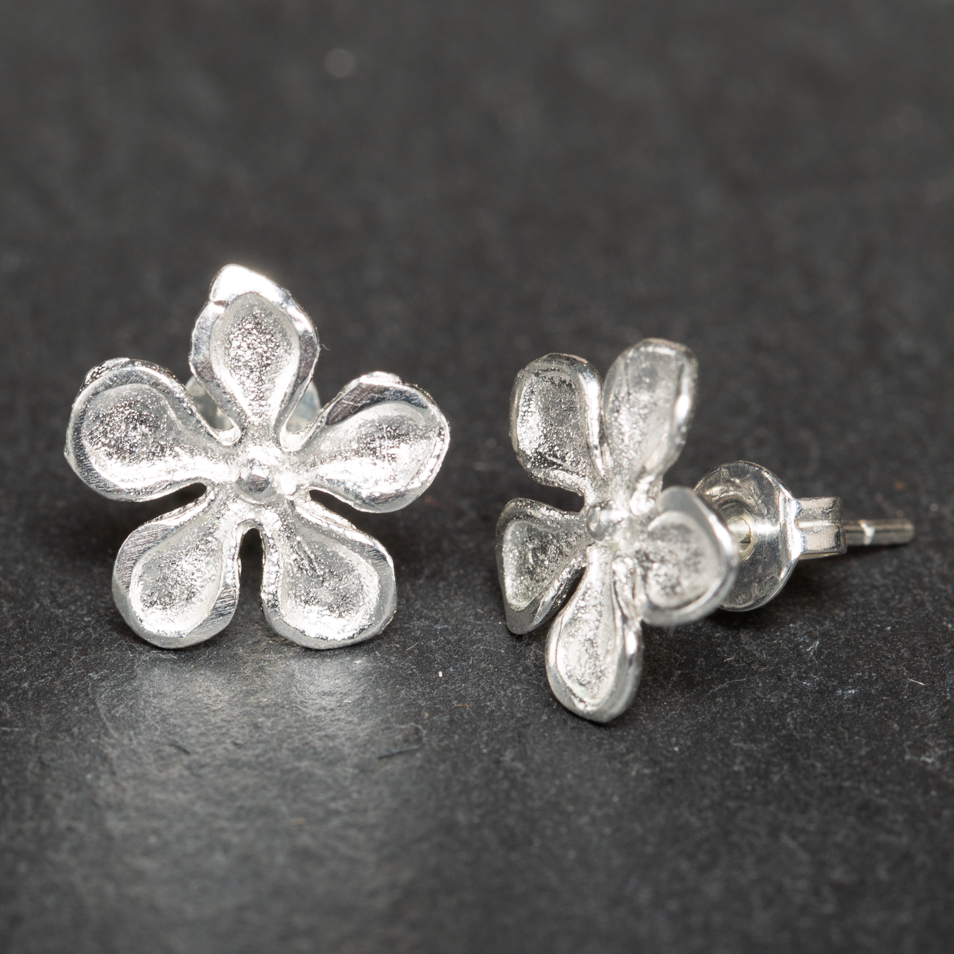 Silver plate hammered flower drop earrings artisan boho jewelry close up view