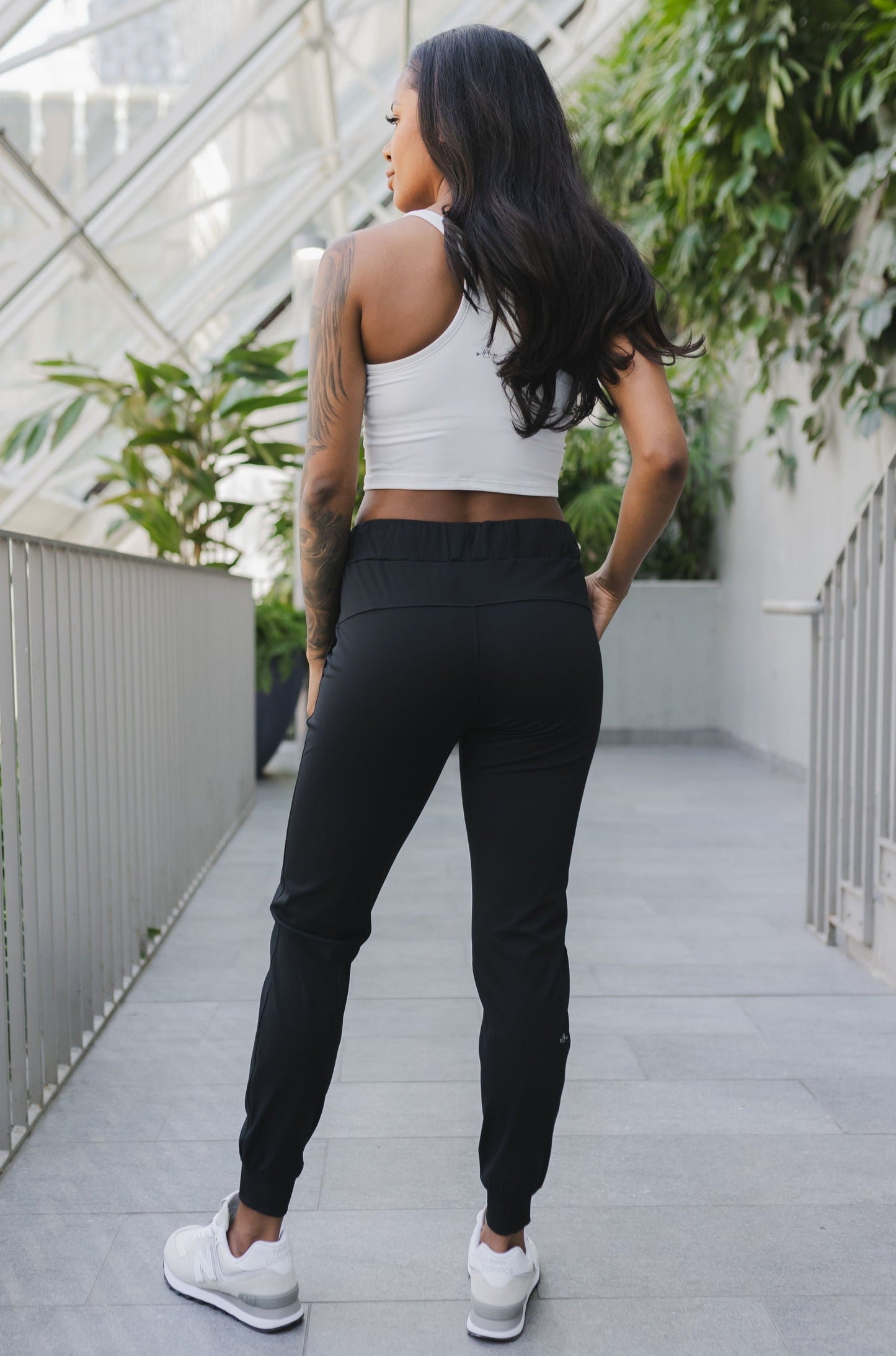 back view of a woman wearing cuffed ankle jogger in black camo for streetwear and everyday wear