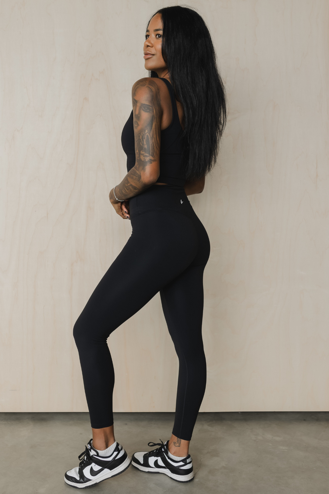 full side view of a woman wearing 25 inch barely there leggings in black for loungewear and athletic wear