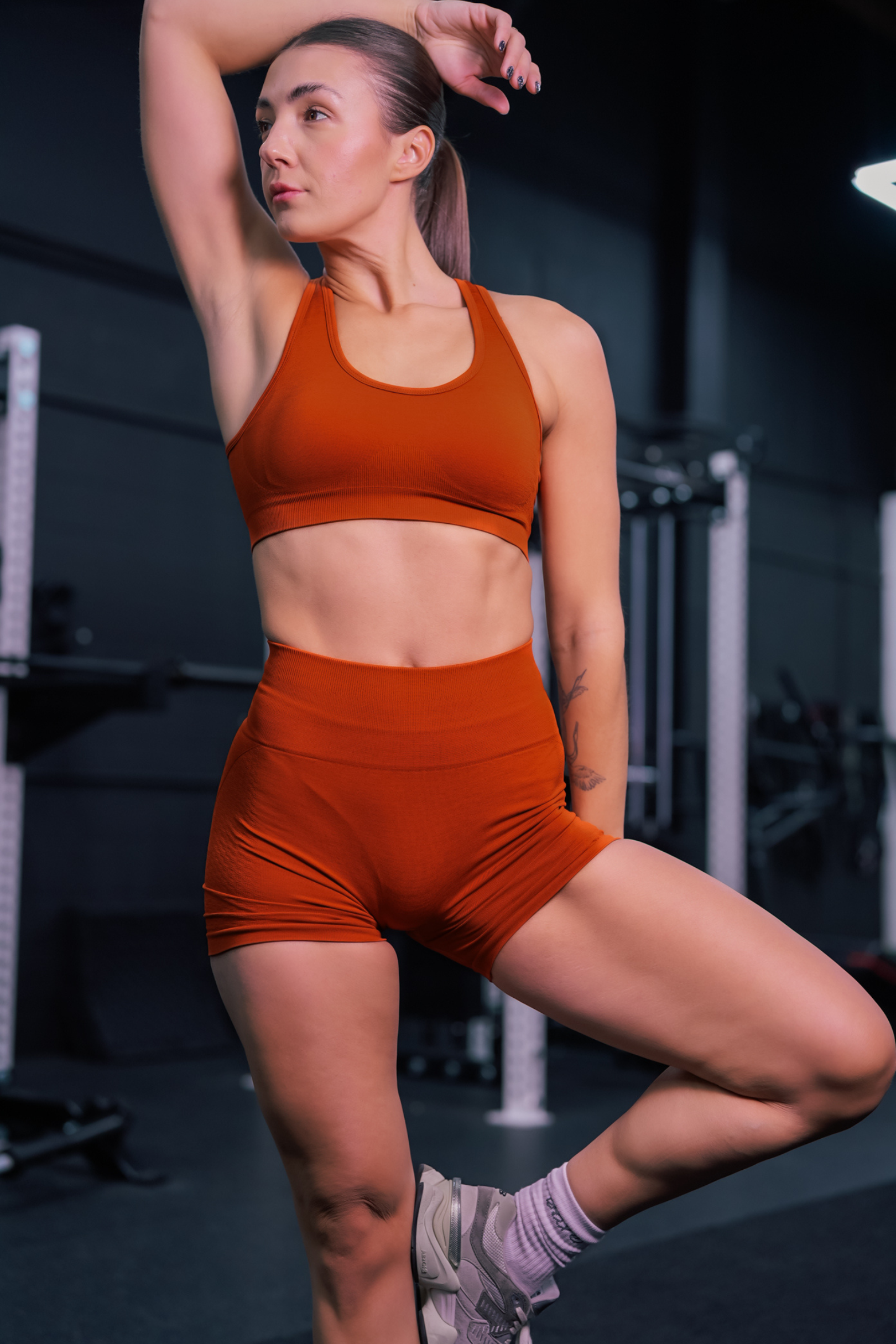 front view of a woman wearing mini scrunch shorts in vermillion for yoga and summer activewear