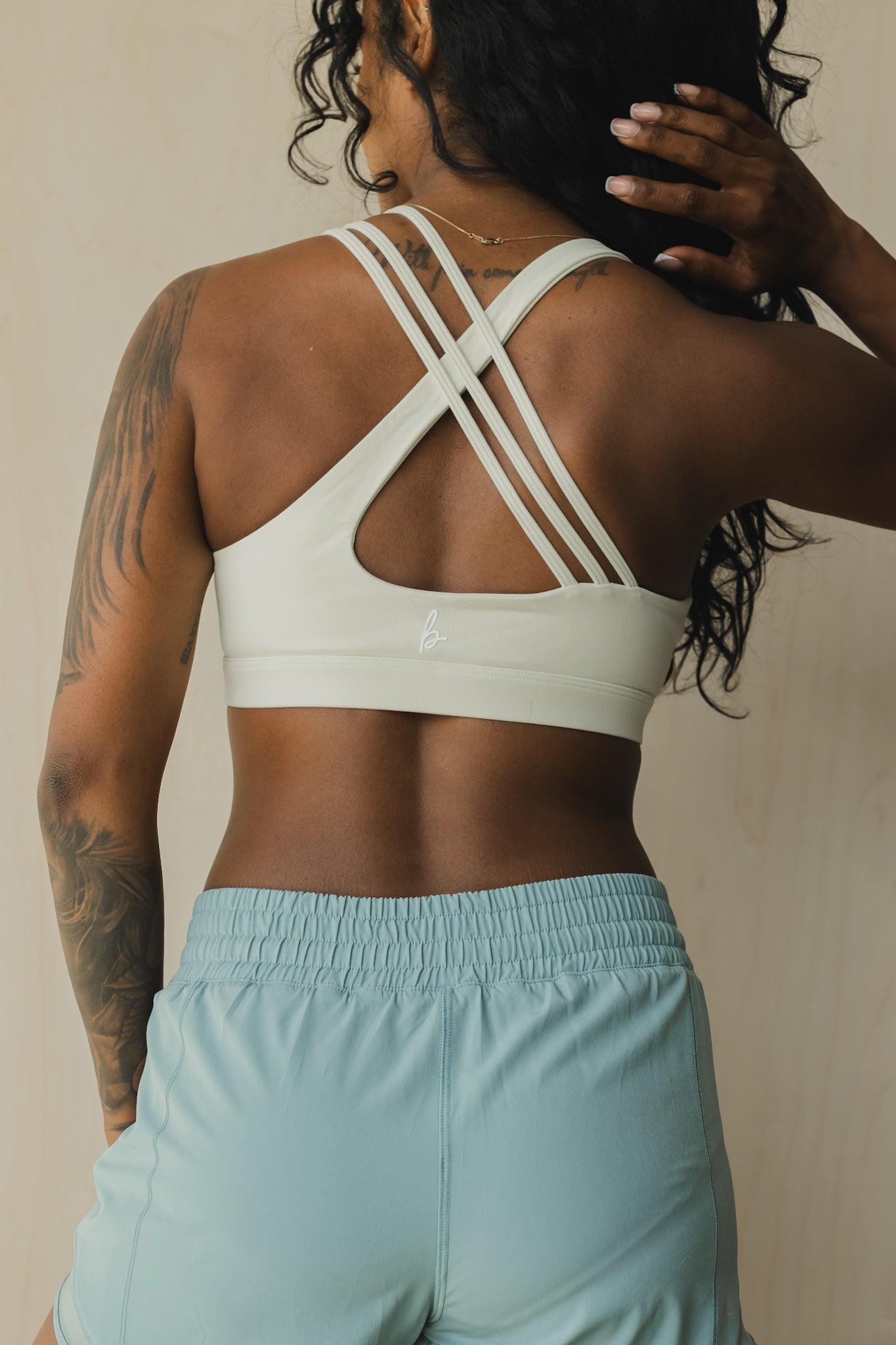 back view of a woman wearing S.F. V3 sports bra in off white for pilates and low impact training