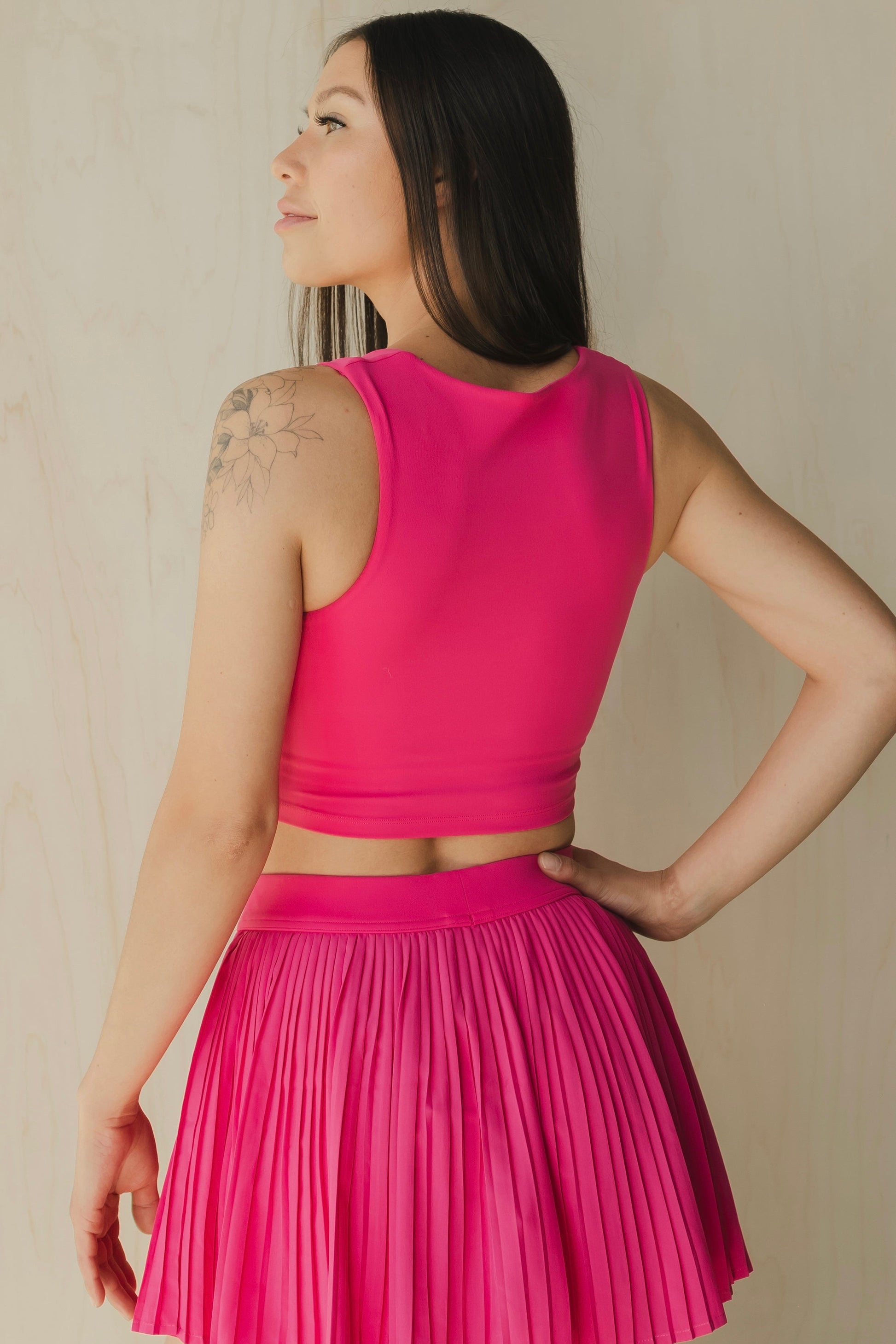 back view of a woman wearing a sweetheart tank top in passion pink for yoga and activewear