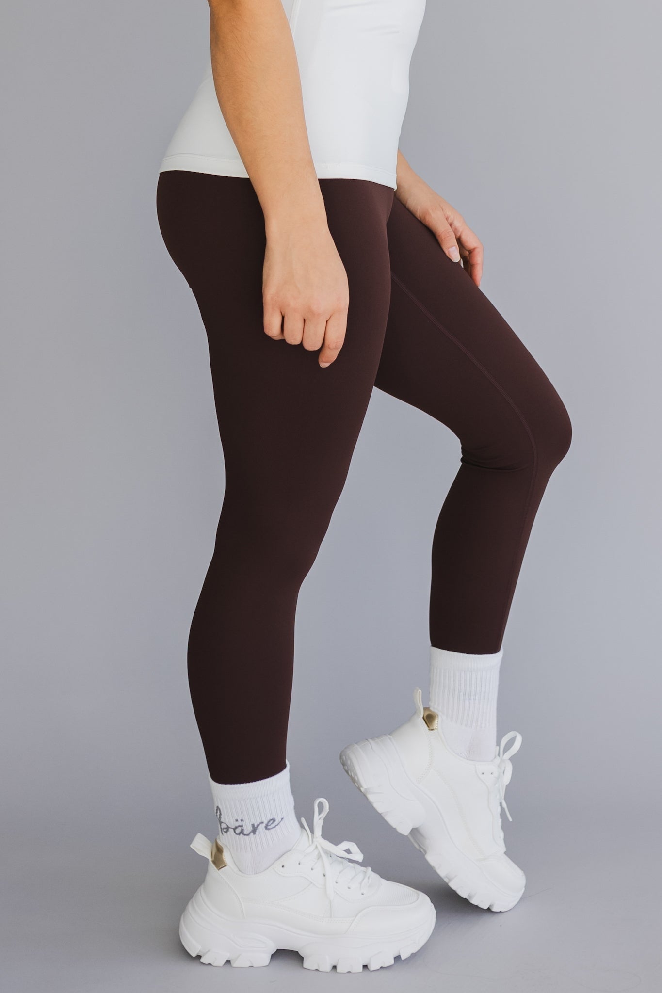side view of a woman wearing 25 inch barely there leggings in coffee for pilates and casual athleisure