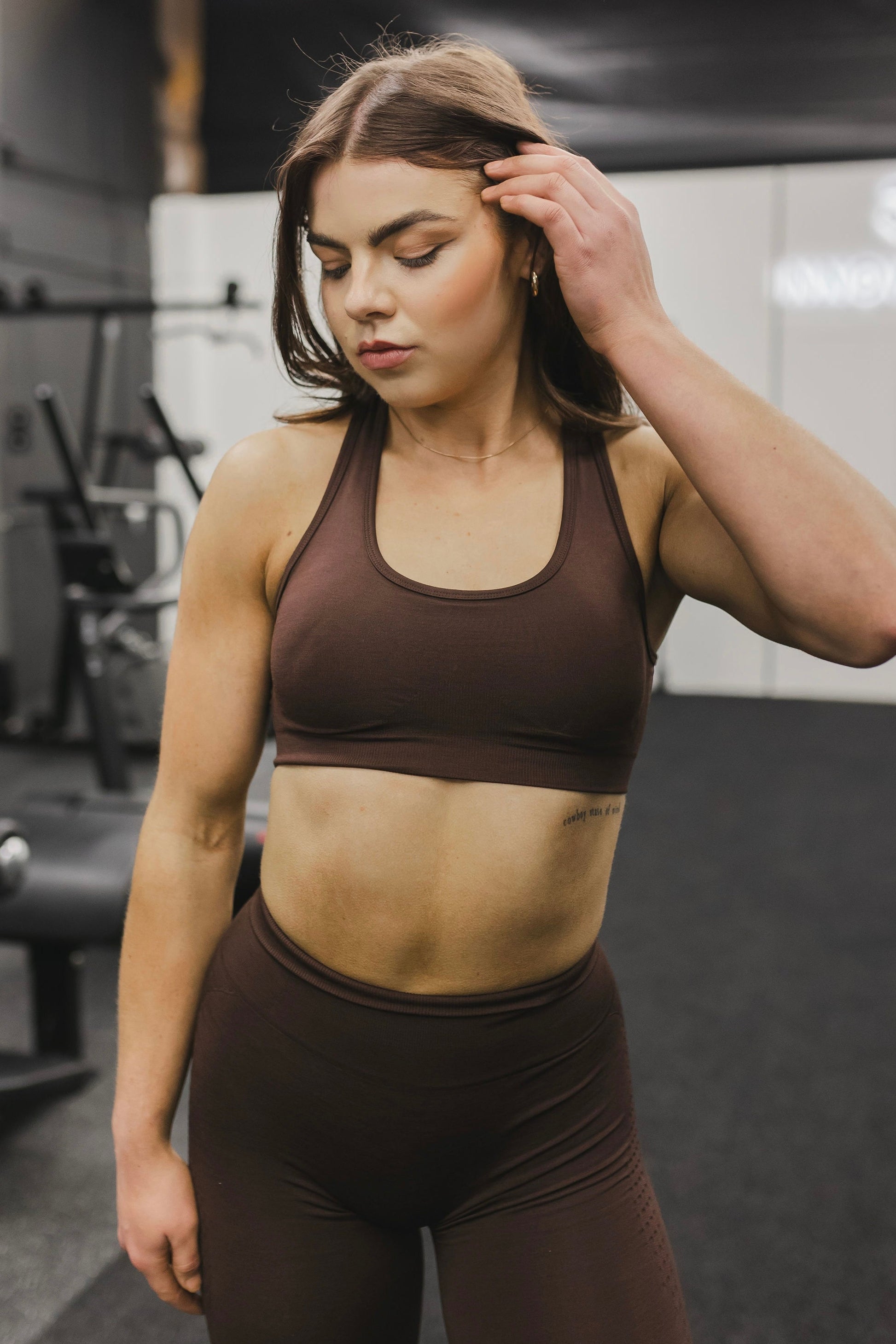 front view of a woman wearing a silhouette seamless sports bra in brown with matching leggings for yoga and fitness
