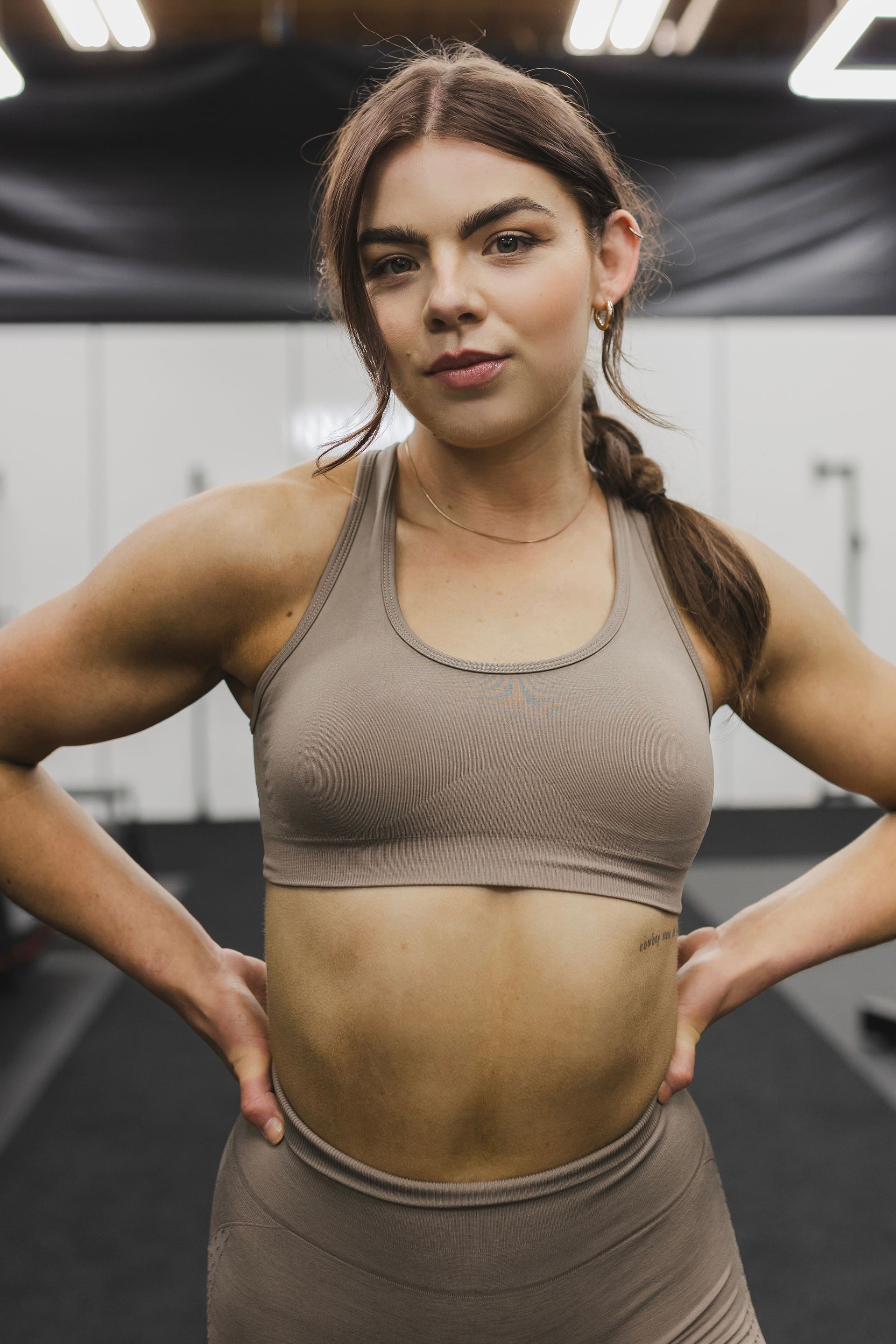 front close up view of a woman wearing a silhouette seamless sports bra in desert storm with matching leggings for yoga and fitness