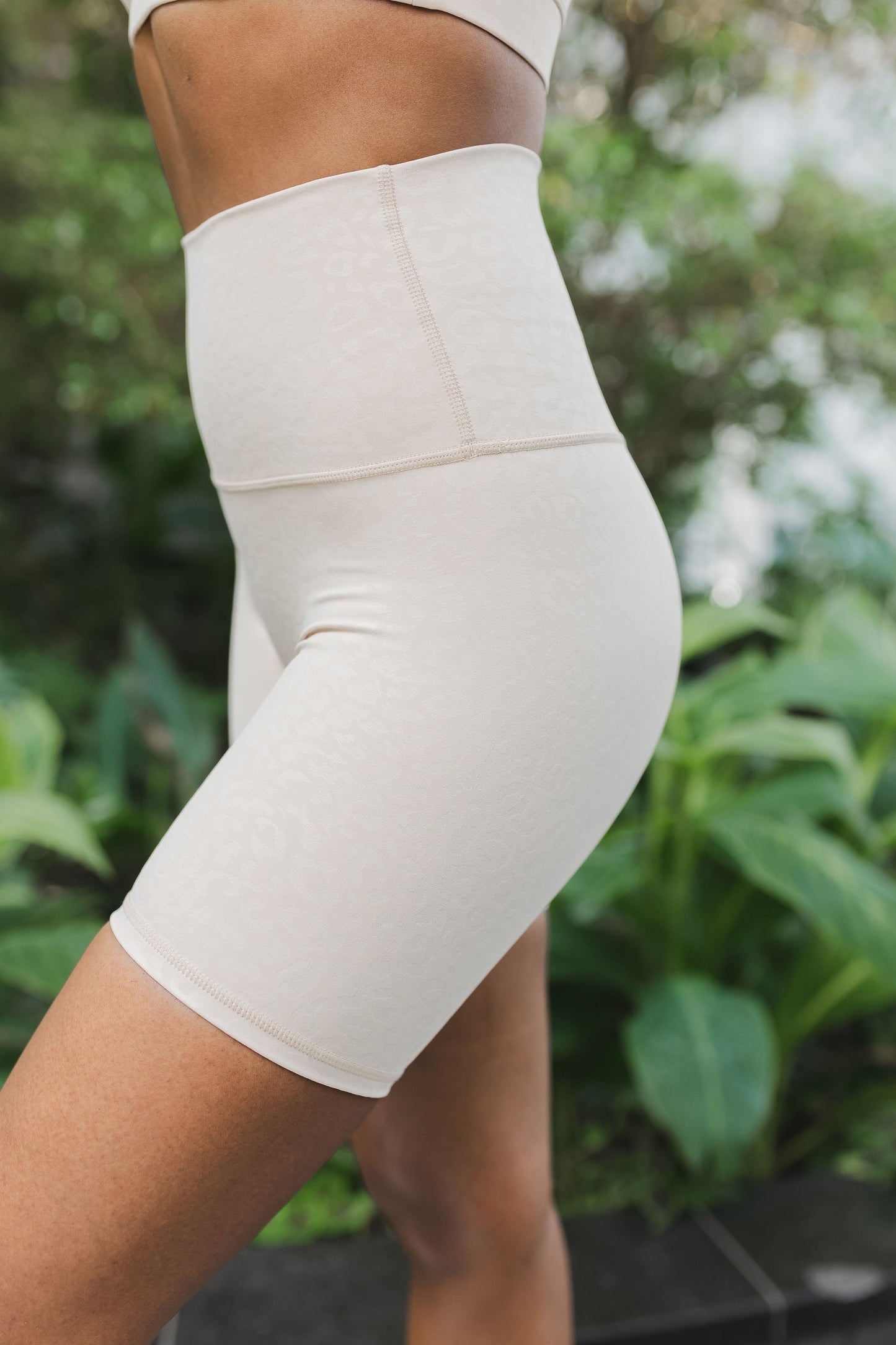 side view of woman wearing barely there 6 inch shorts in ivory leopard print for yoga and activewear