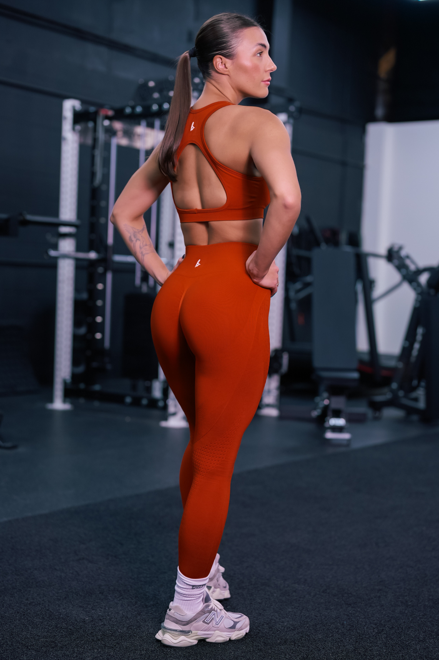 back view of a woman wearing mini scrunch leggings in vermillion for hot yoga and studio workouts