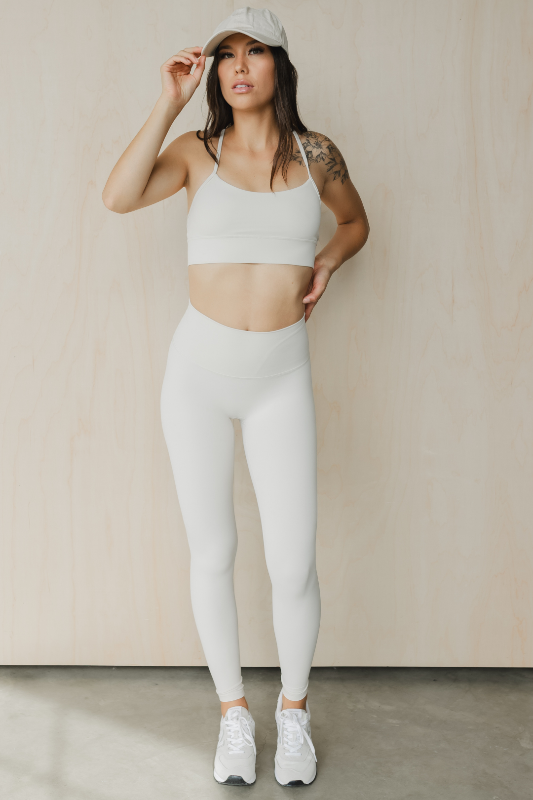 full front front view of a woman wearing a barely there sports bra in dove white for yoga and studio workouts
