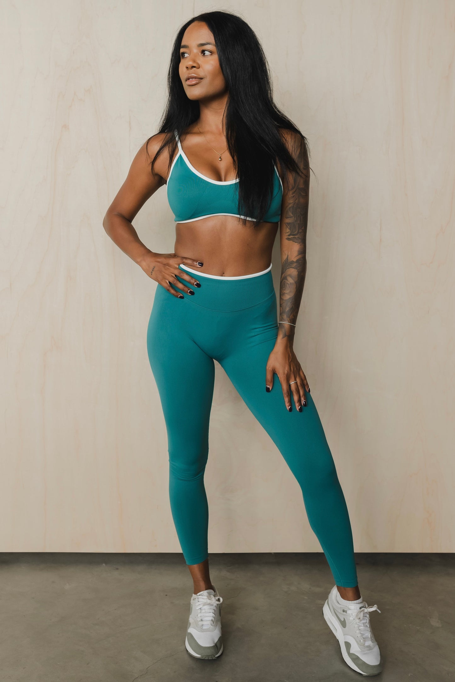 full front view of a woman wearing a sculpt sports bra with ribbed piqué fabric in teal for yoga and fitness