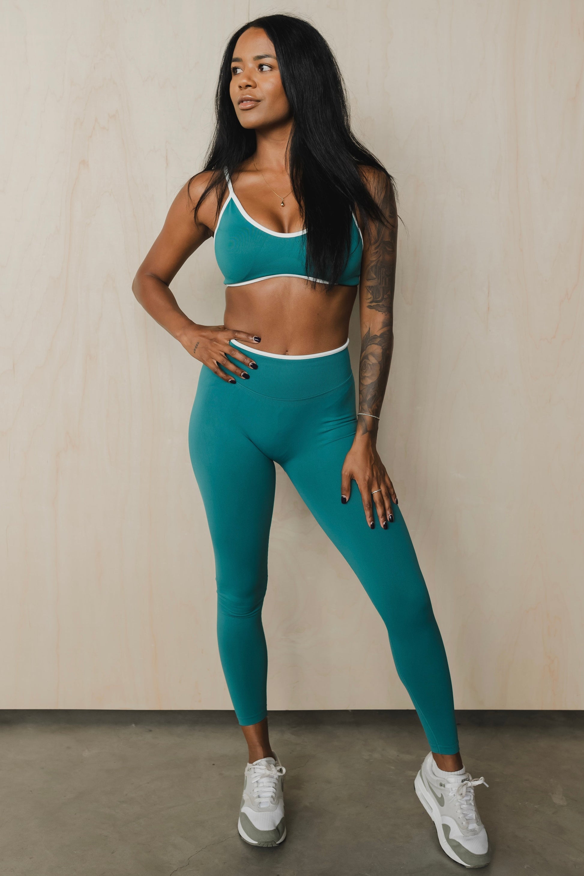 full front view of a woman wearing a sculpt sports bra with ribbed piqué fabric in teal for yoga and fitness