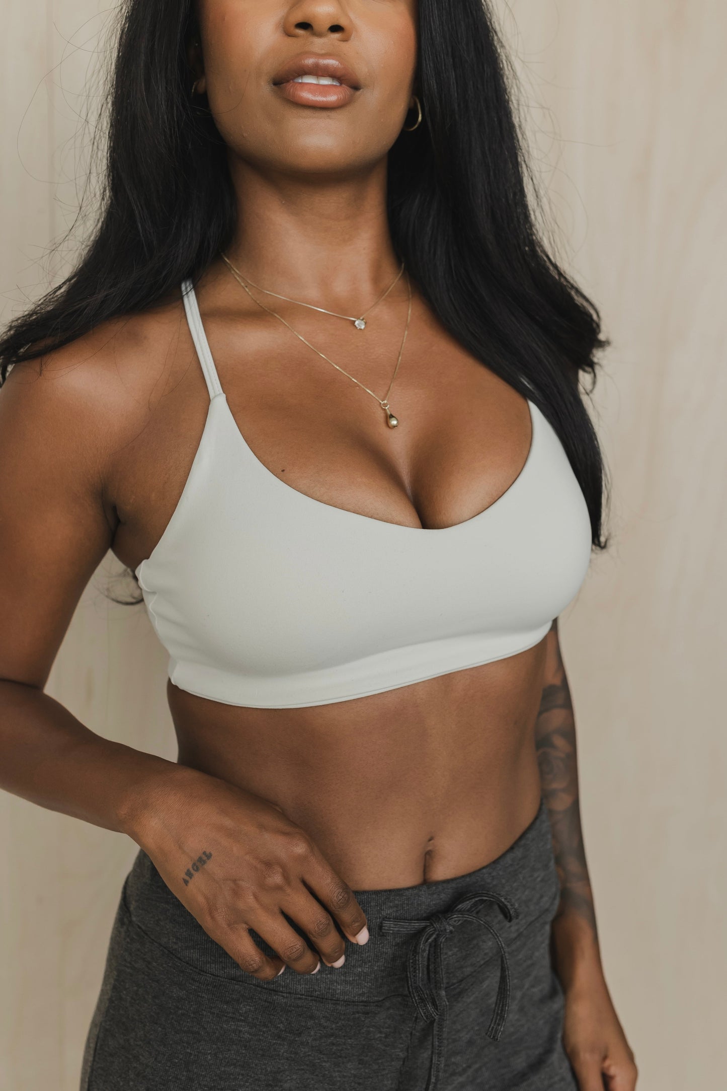 front view of woman wearing divine sports bra in greyish white for hot yoga and summer workouts