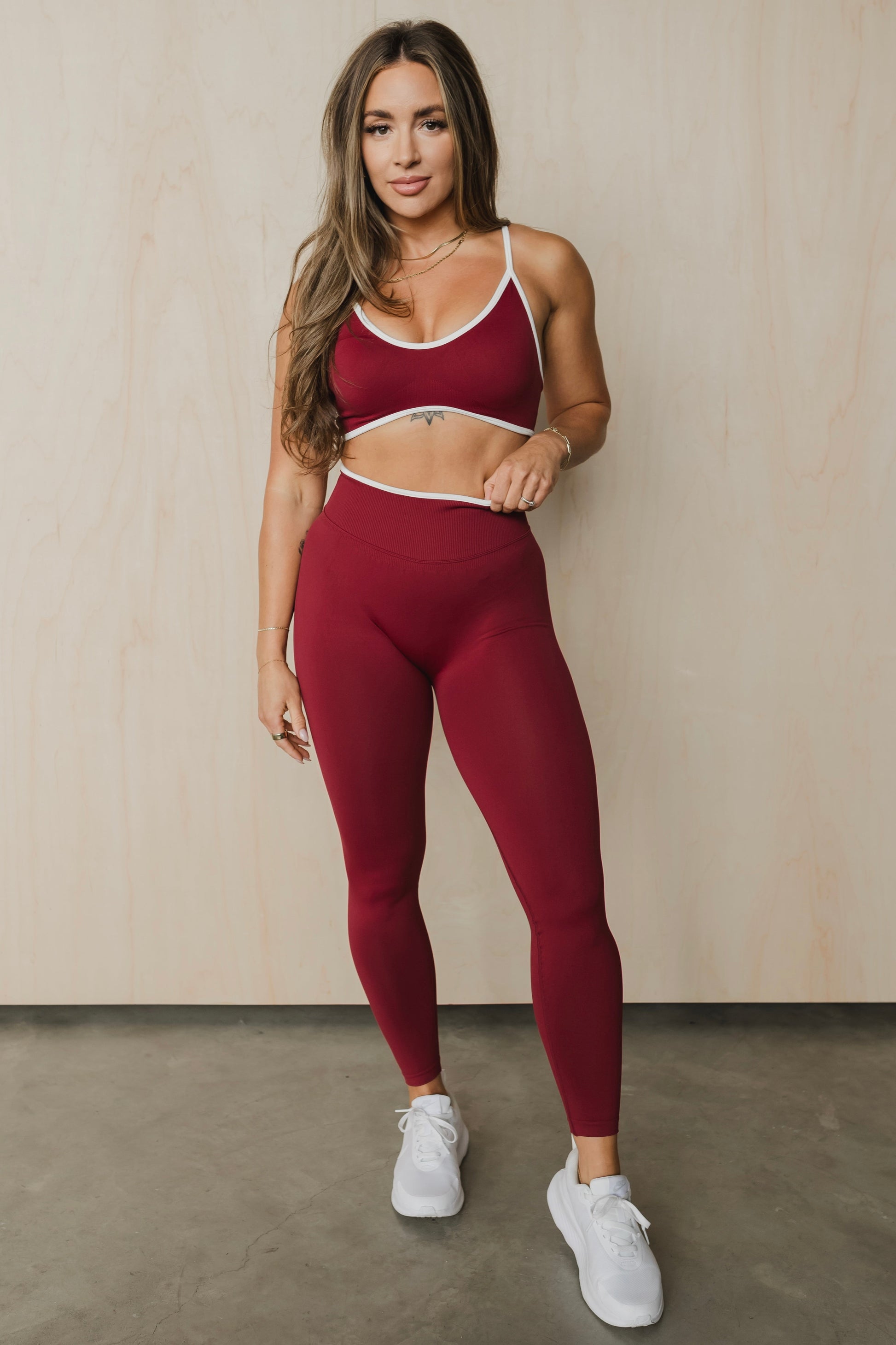 full front view of a woman wearing a sculpt sports bra with ribbed piqué fabric in maroon for yoga and fitness