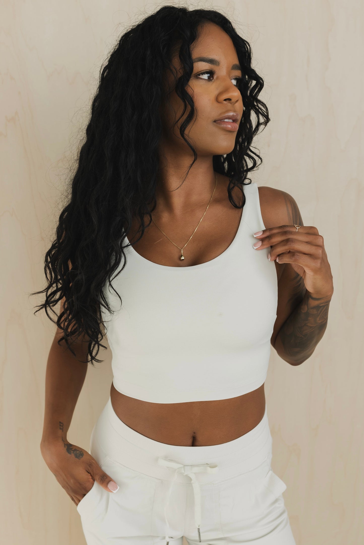 front view of a woman wearing wrap back sports bra in buff beige for yoga and fitness