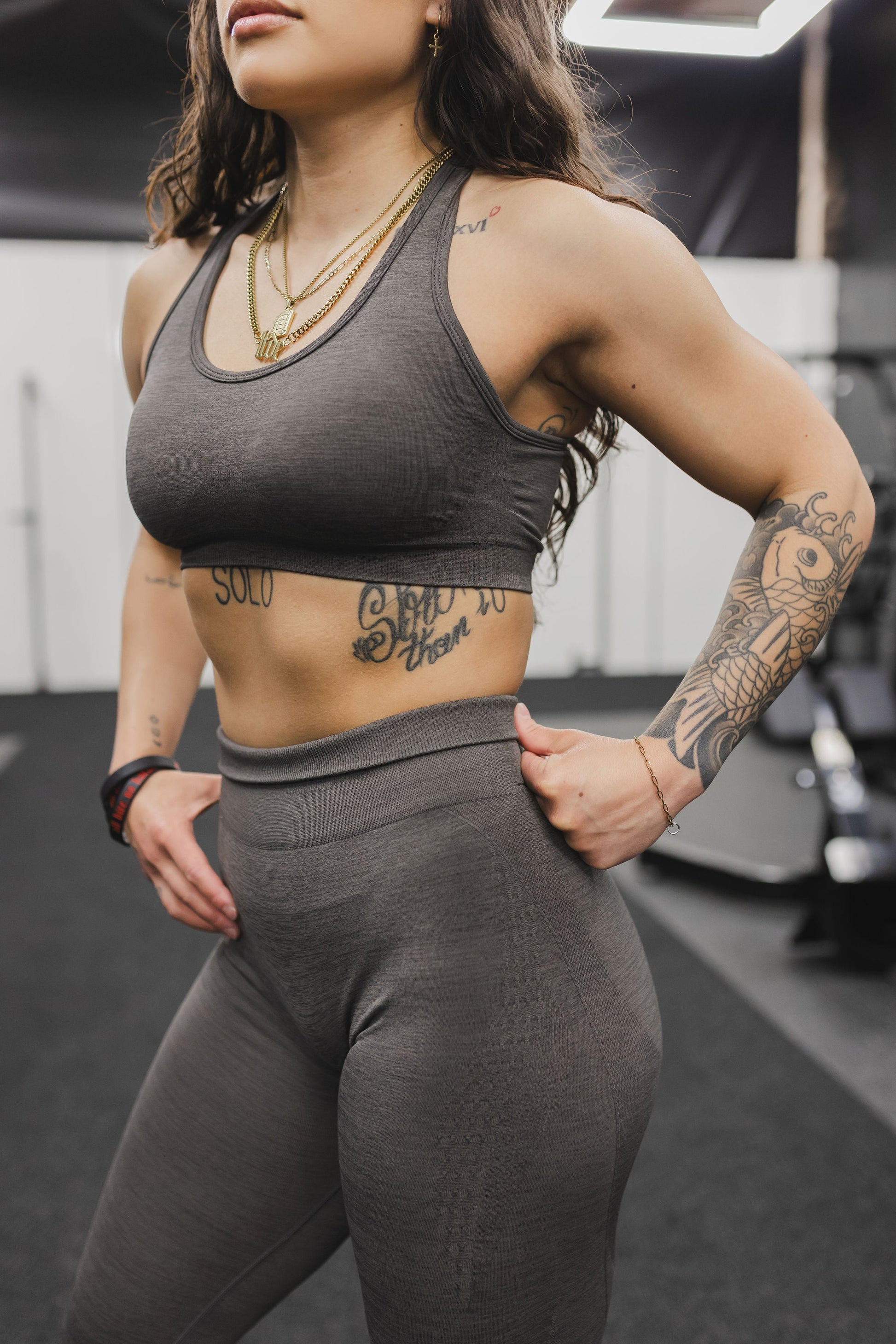 side view of a woman wearing a silhouette seamless sports bra in dark grey with matching leggings for yoga and fitness
