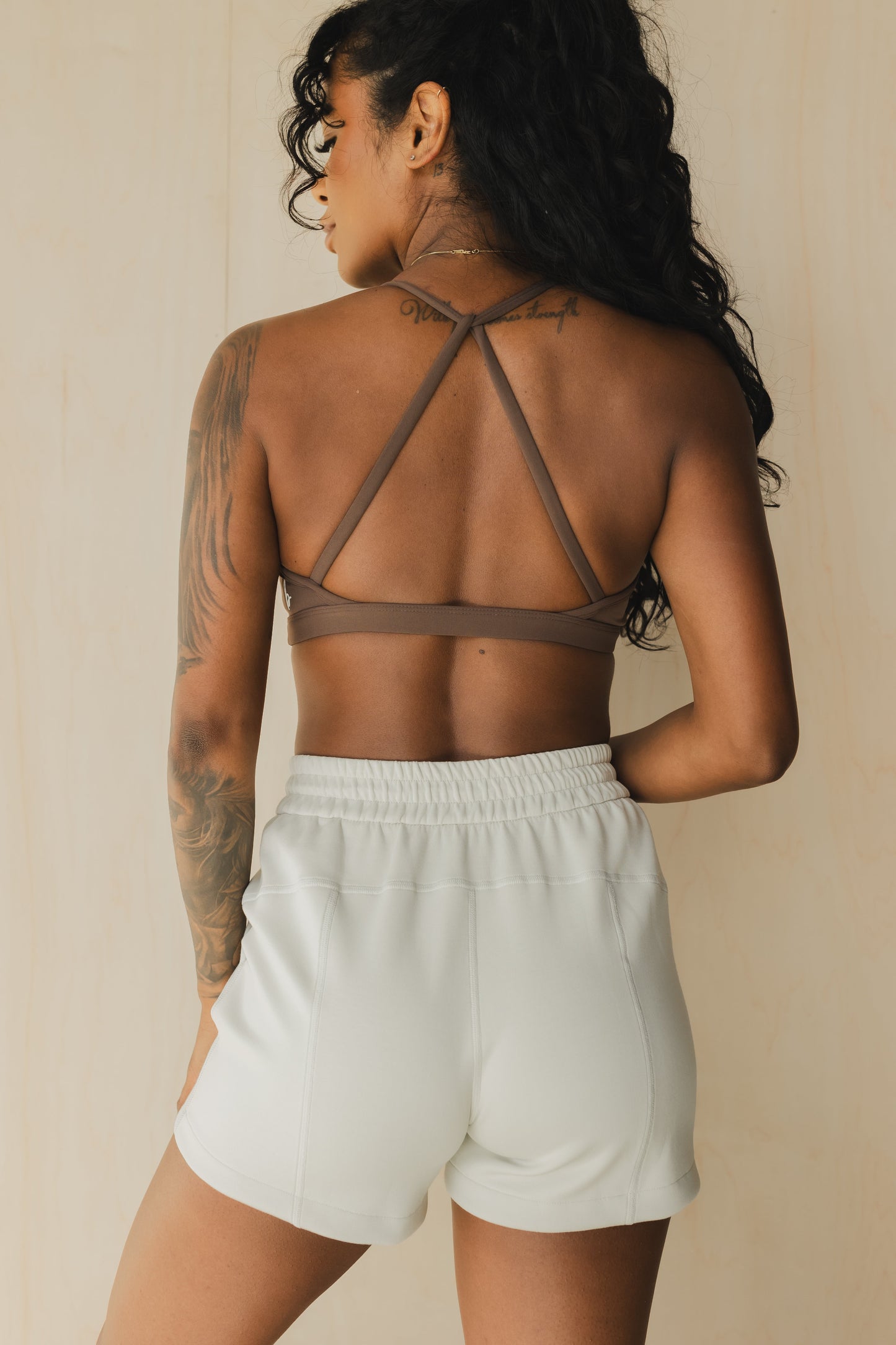 back view of a woman wearing a mini scrunch bra in dusty brown for yoga and summer workouts