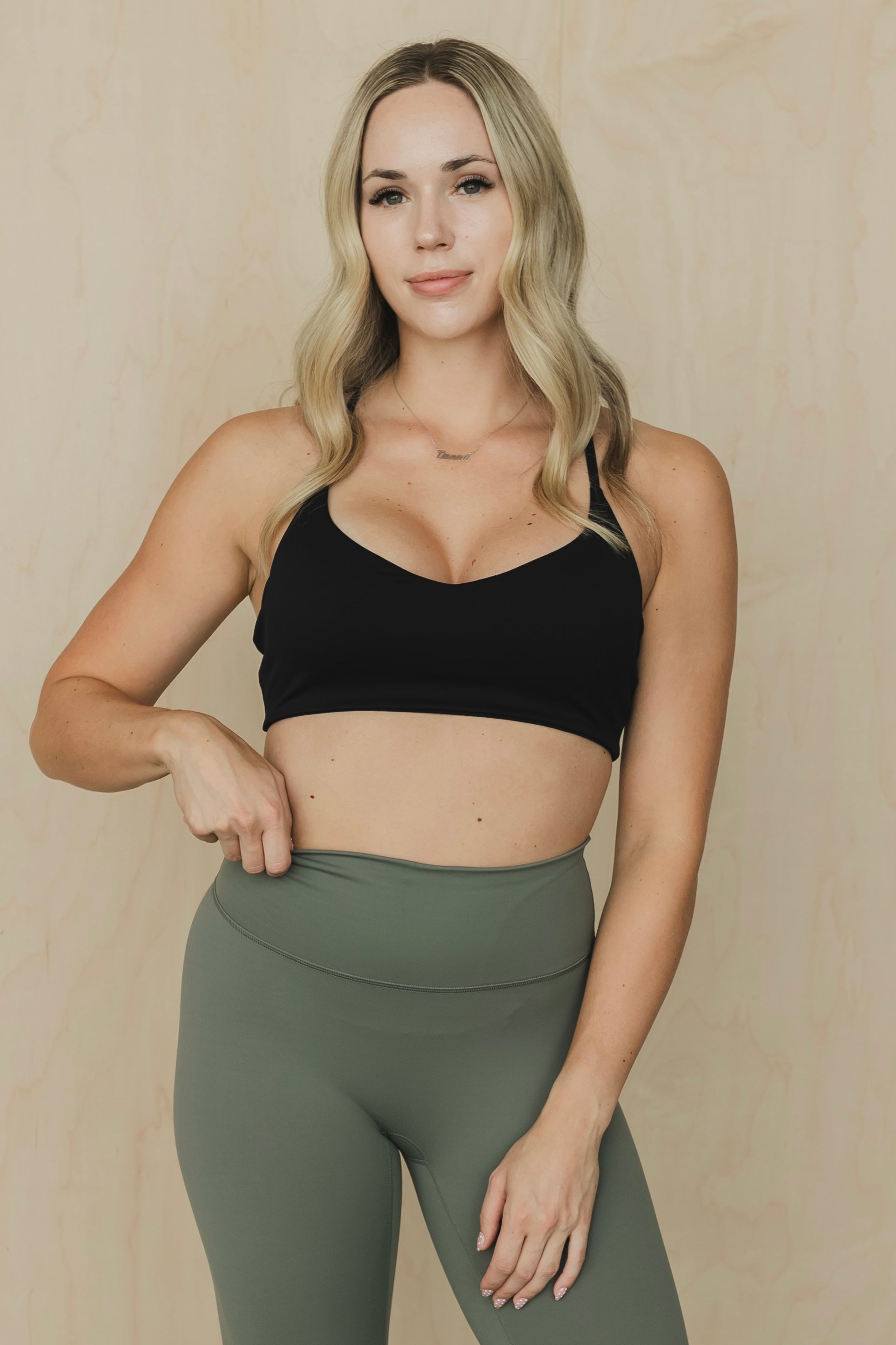 front view of woman wearing divine sports bra in black for high impact training and everyday wear