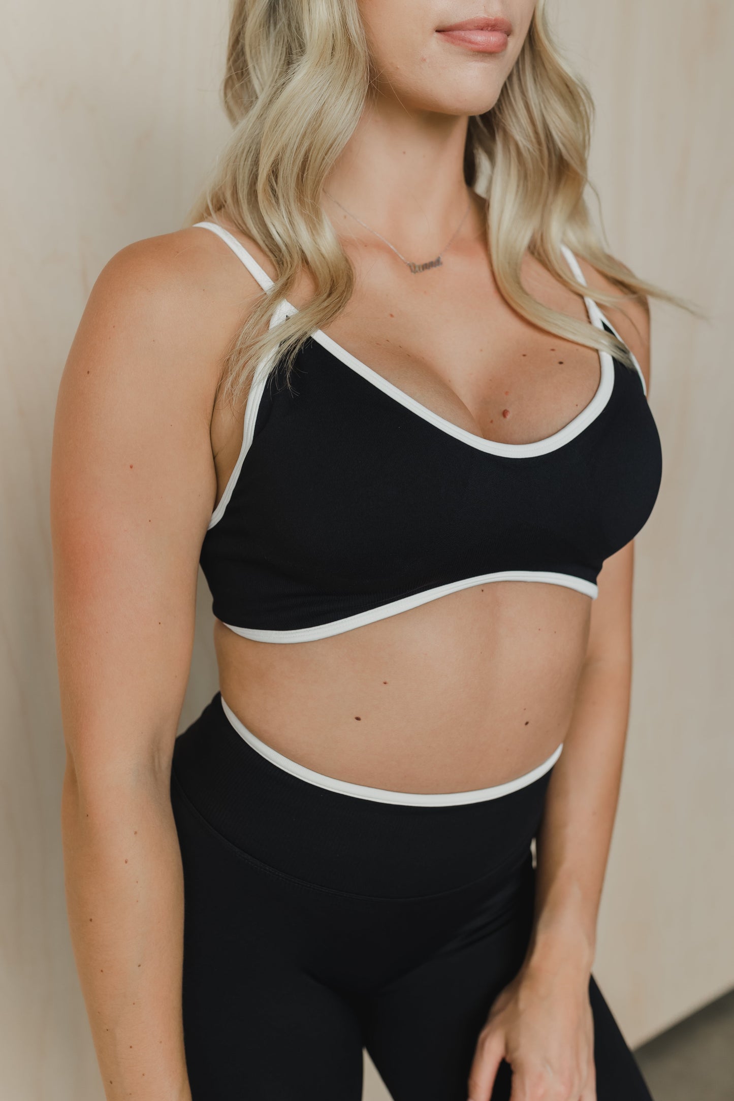 close up front view of a woman wearing a sculpt sports bra with ribbed piqué fabric in black for yoga and fitness