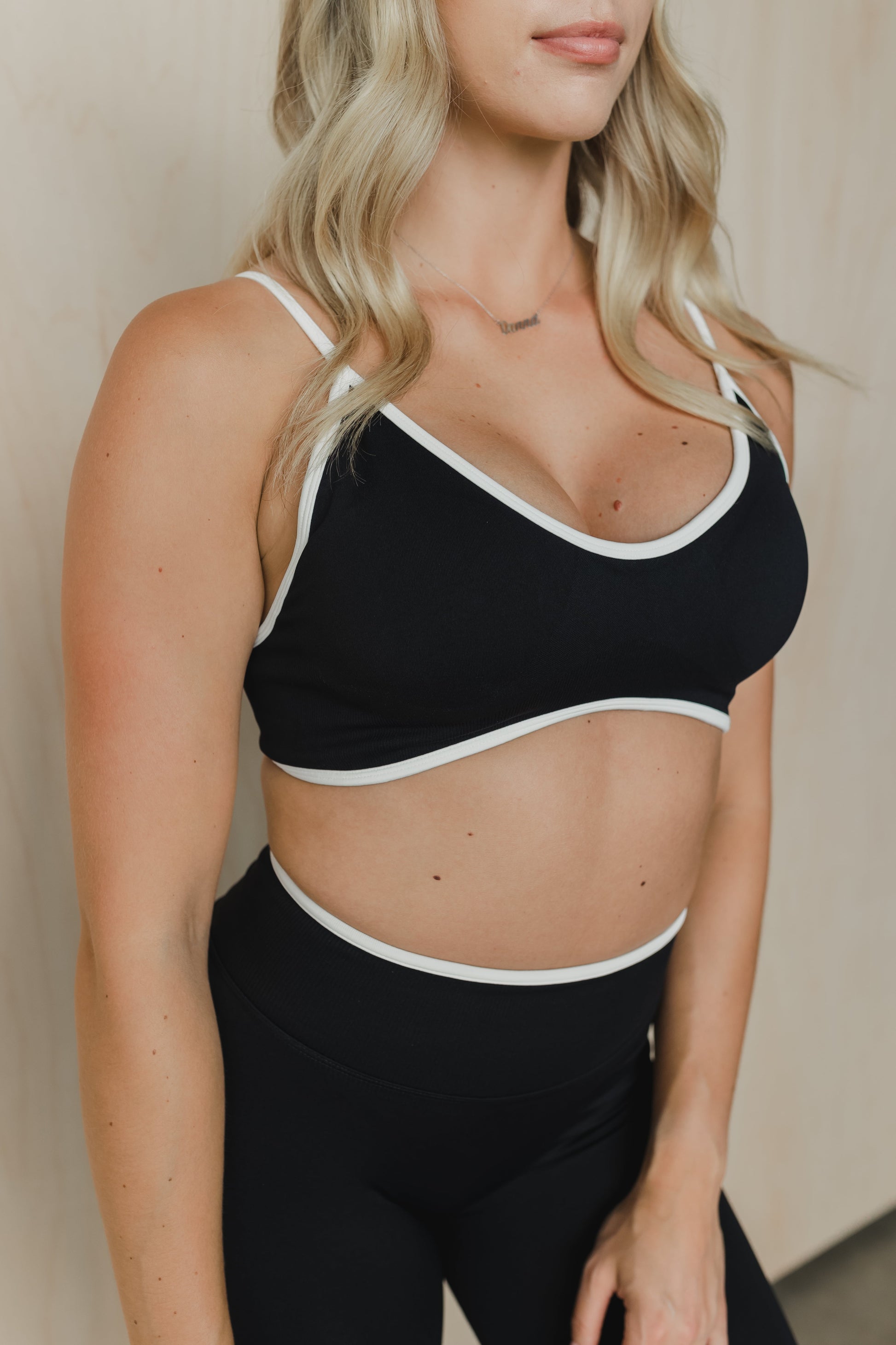 close up front view of a woman wearing a sculpt sports bra with ribbed piqué fabric in black for yoga and fitness