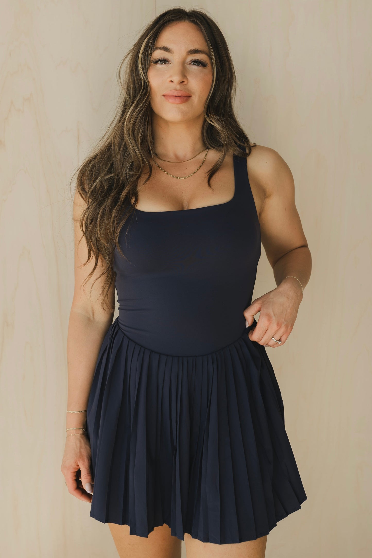 front view of woman wearing street to Court activewear dress in midnight blue with built-in bra for tennis and yoga