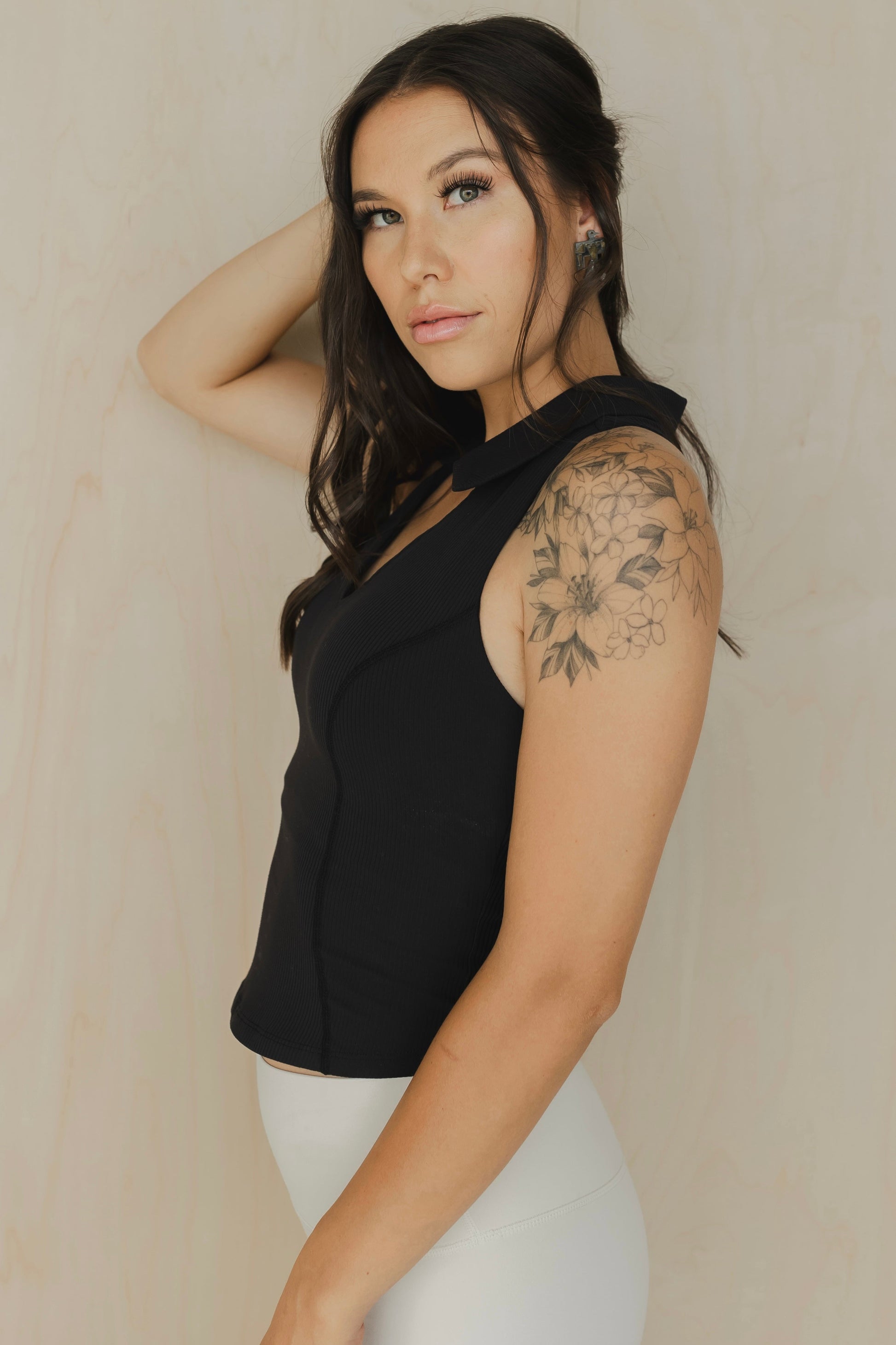 side view of a woman wearing a Ace tank top in black for golf yoga and activewear