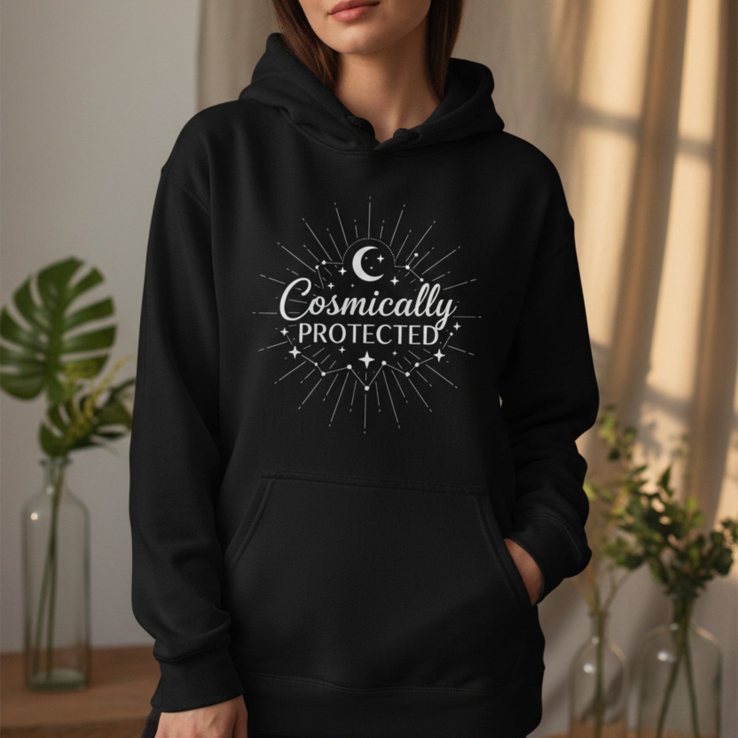 Black cosmically protected pullover hoodie with white starburst moon design — witchy spiritual gift for empaths and healers who wrap themselves in cosmic protection every day