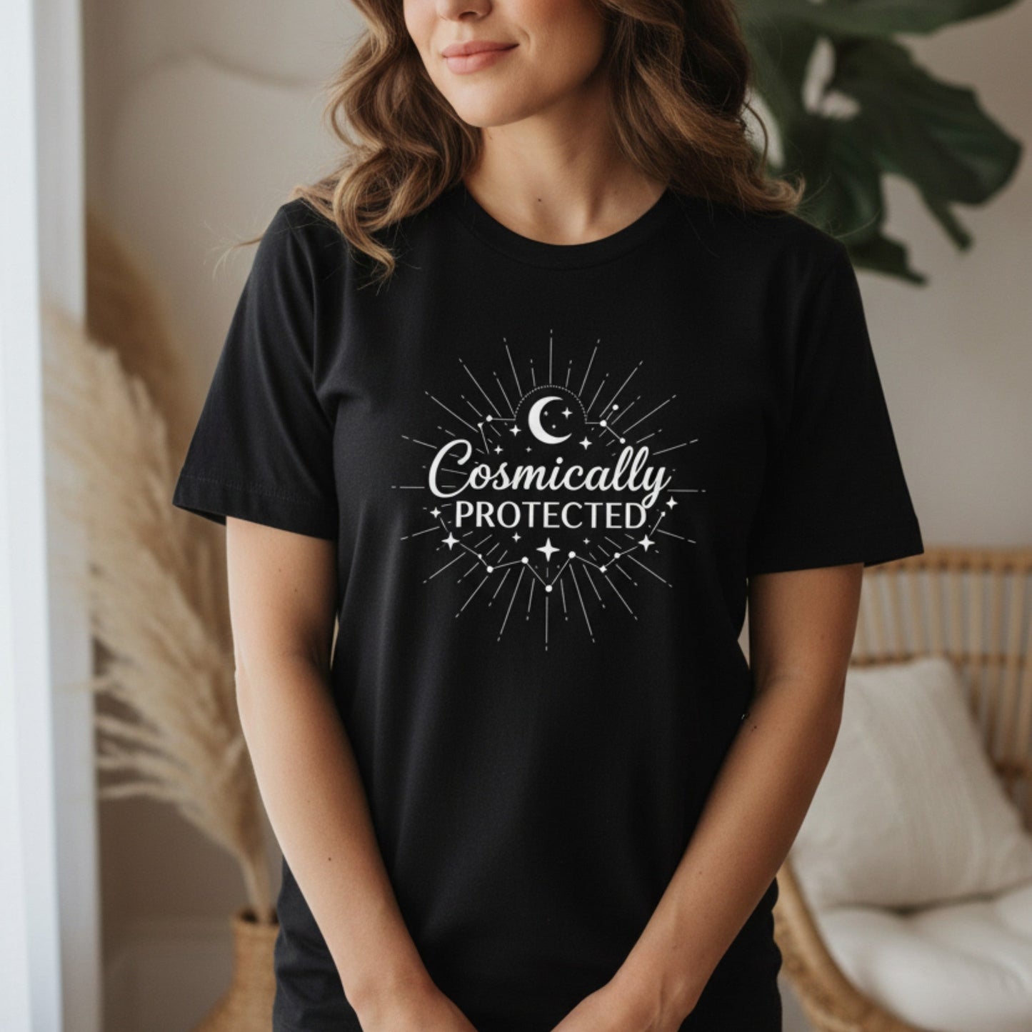Black cosmically protected t-shirt with white starburst moon design — witchy empowerment tee for healers and spiritual women who know they are never alone