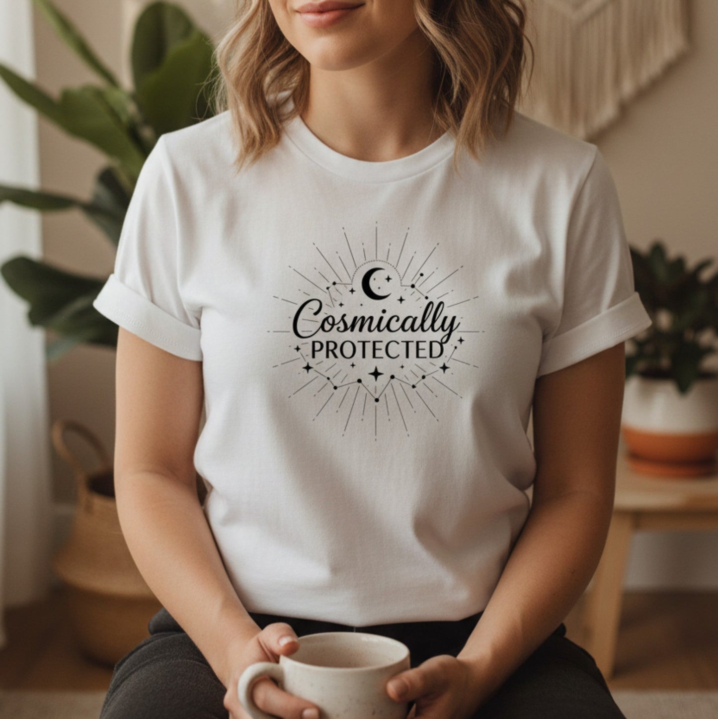 White cosmically protected graphic tee with black celestial sunburst design — clean everyday spiritual shirt for the woman who carries quiet faith into every room she enters