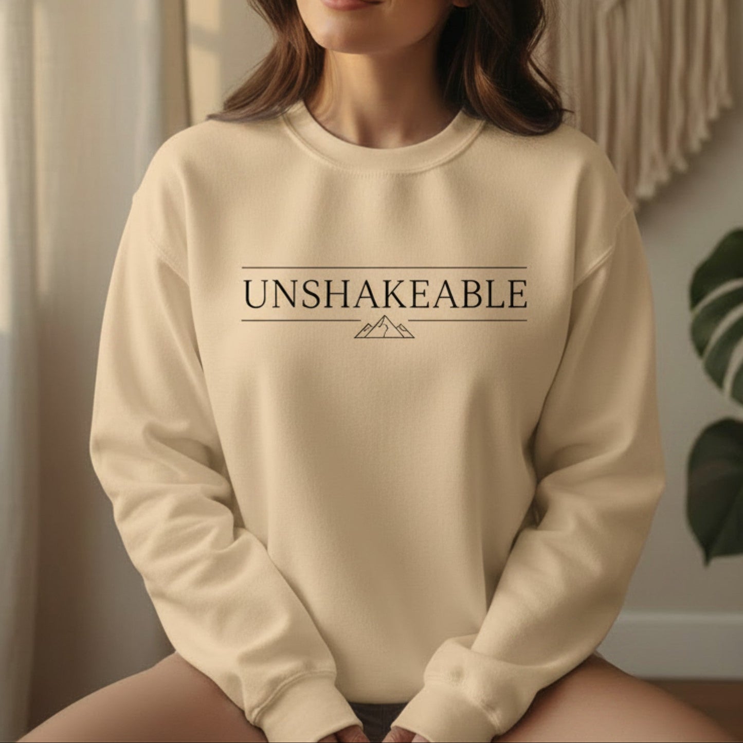 Sand Unshakeable crewneck sweatshirt with black serif typography and mountain detail — earthy minimal empowerment gift for the grounded woman who has done the work and knows her worth