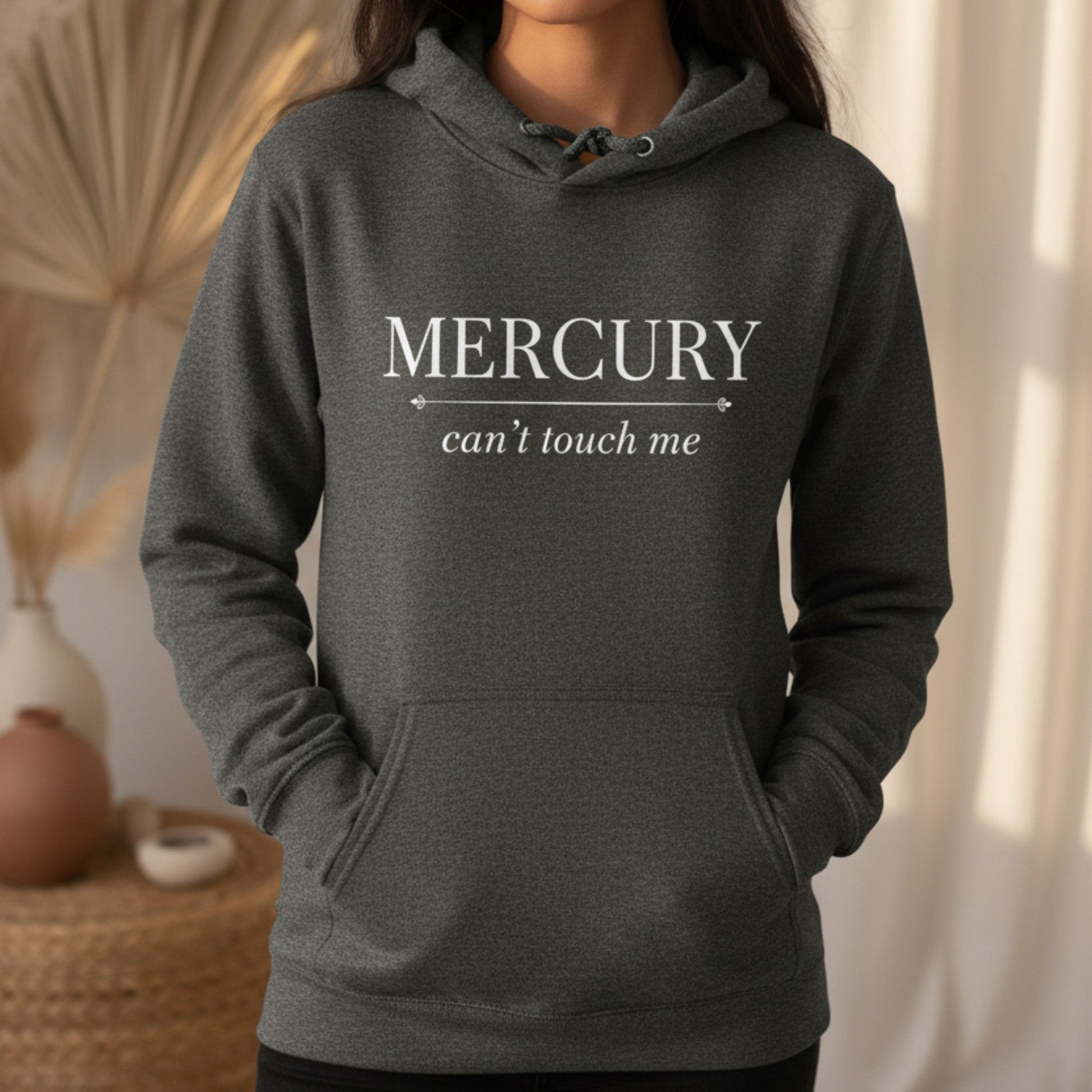 Dark heather gray Mercury Can't Touch Me pullover hoodie with black astrology typography — cozy retrograde season gift for the woman who laughs at Mercury and keeps going