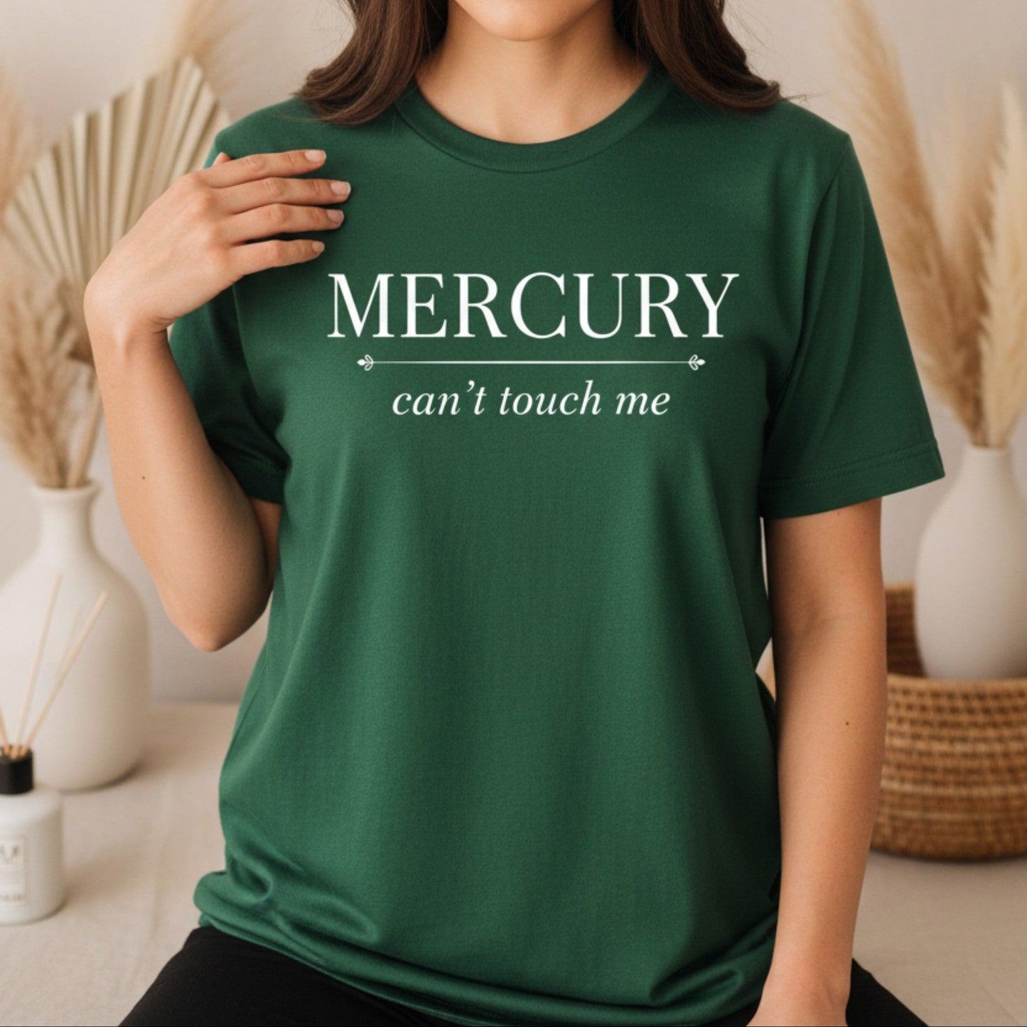 Forest green Mercury Can't Touch Me tee with white celestial typography — earthy boho astrology gift for the woman who stays rooted while Mercury does its thing