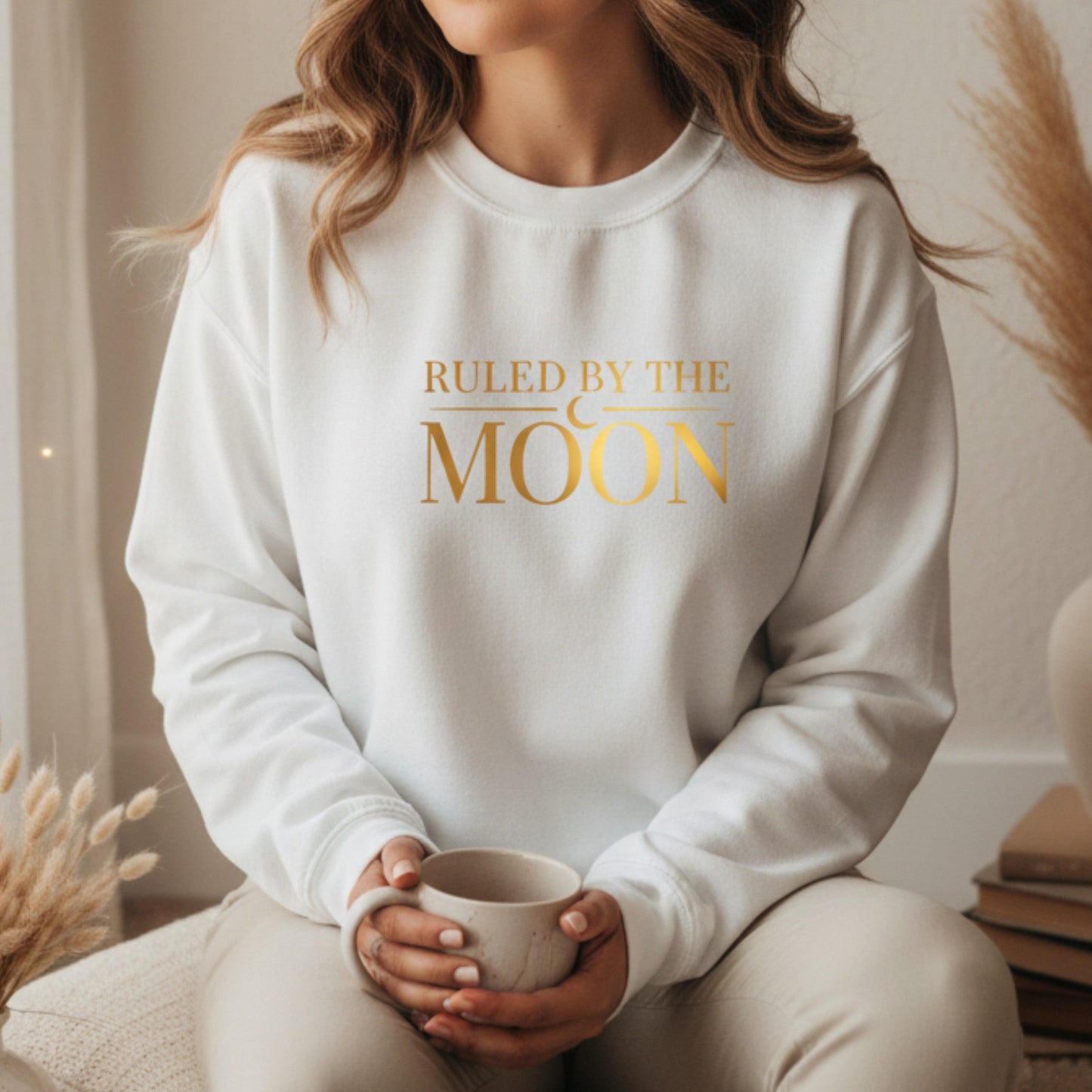 White fleece crewneck with gold ruled by the moon graphic — boho spiritual sweatshirt for new moon rituals and cozy self-care days