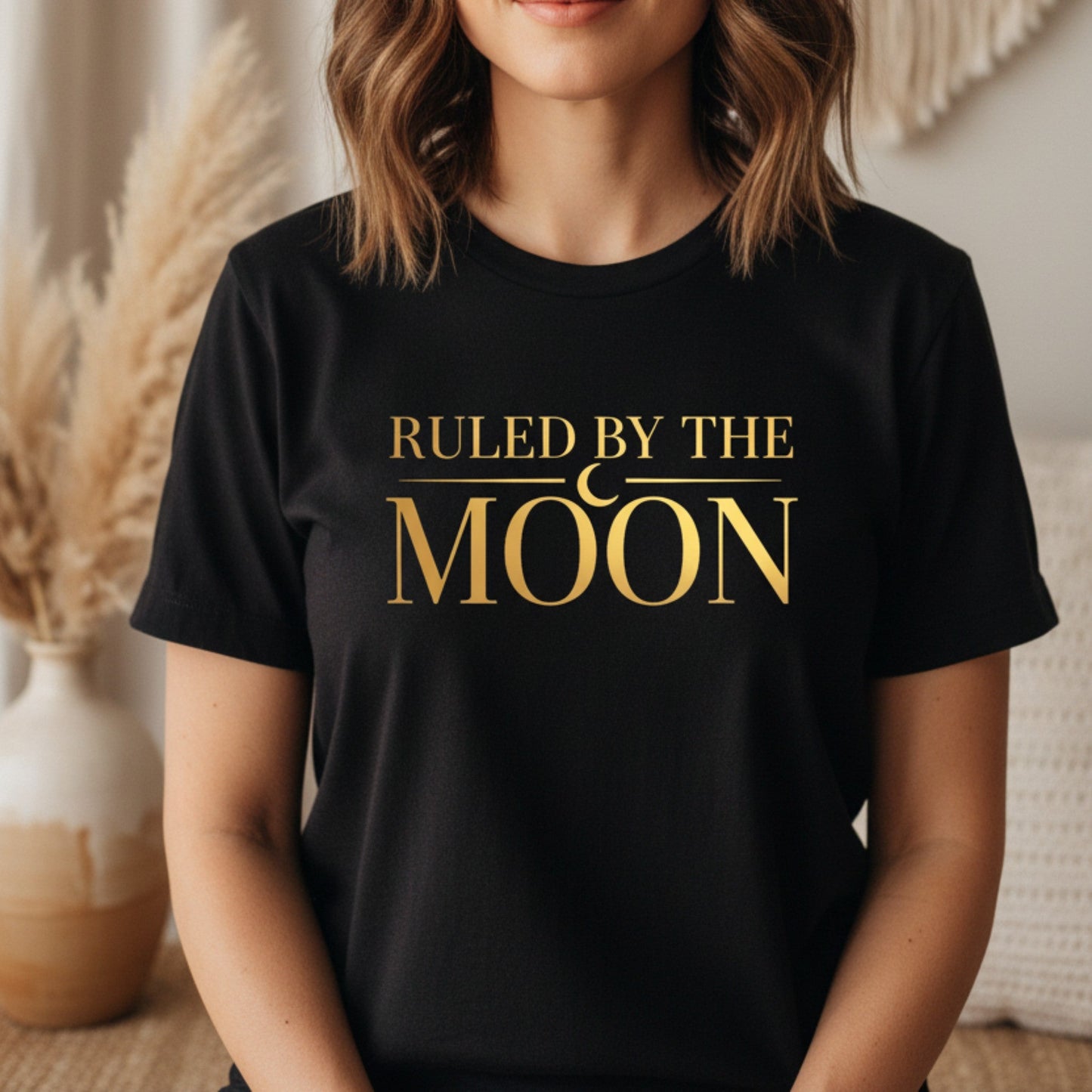Black women's graphic tee with gold crescent moon print — celestial statement shirt for the woman who trusts her intuition over everything