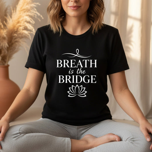 Black Breath Is The Bridge graphic tee with white typography and lotus detail — bold mindfulness gift for the spiritual woman who knows the breath is the most powerful tool she carries
